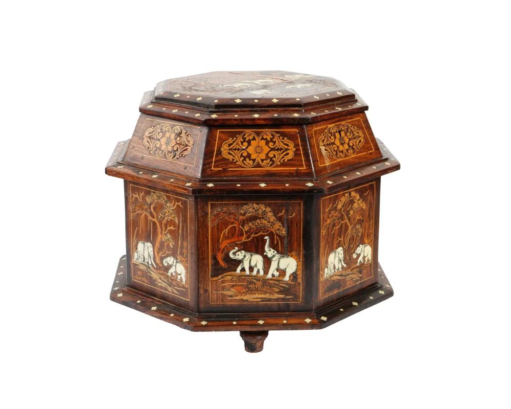 Ancienne boîte à bibelots monumentale anglo-indienne en bois avec marqueterie représentant des éléphants, avec couvercle à charnière verrouillable par clé. Vraisemblablement en Inde, à l'époque du Raj britannique. Pièce octogonale à pied avec