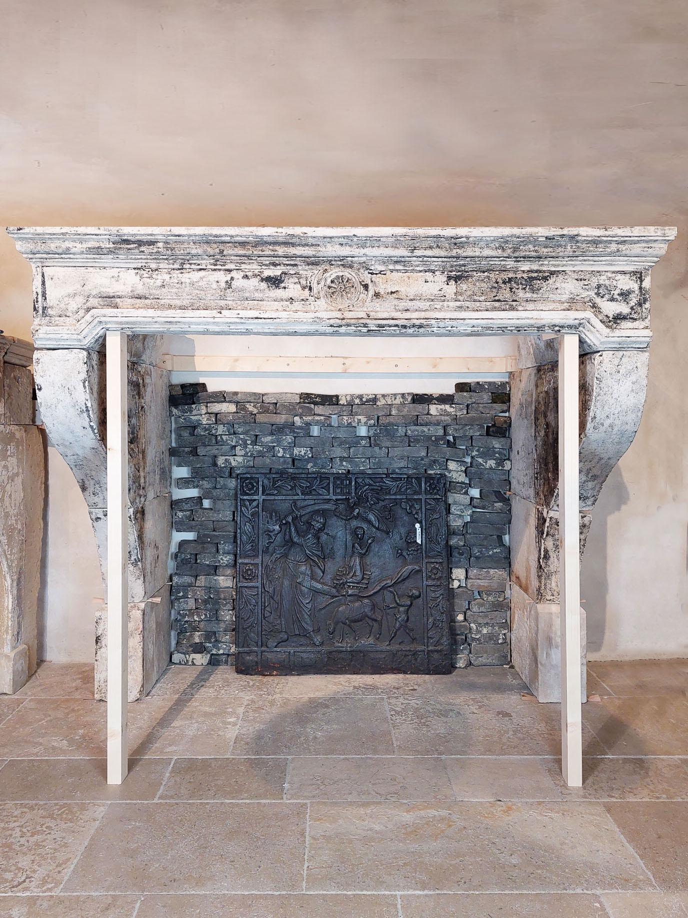 A special 17th-century French Antique Castle Mantelpiece. Carved from exquisite light limestone, this monumental fireplace boasts traces of its original paint layer, evoking a sense of history and charm. Its unique front, crafted from a single