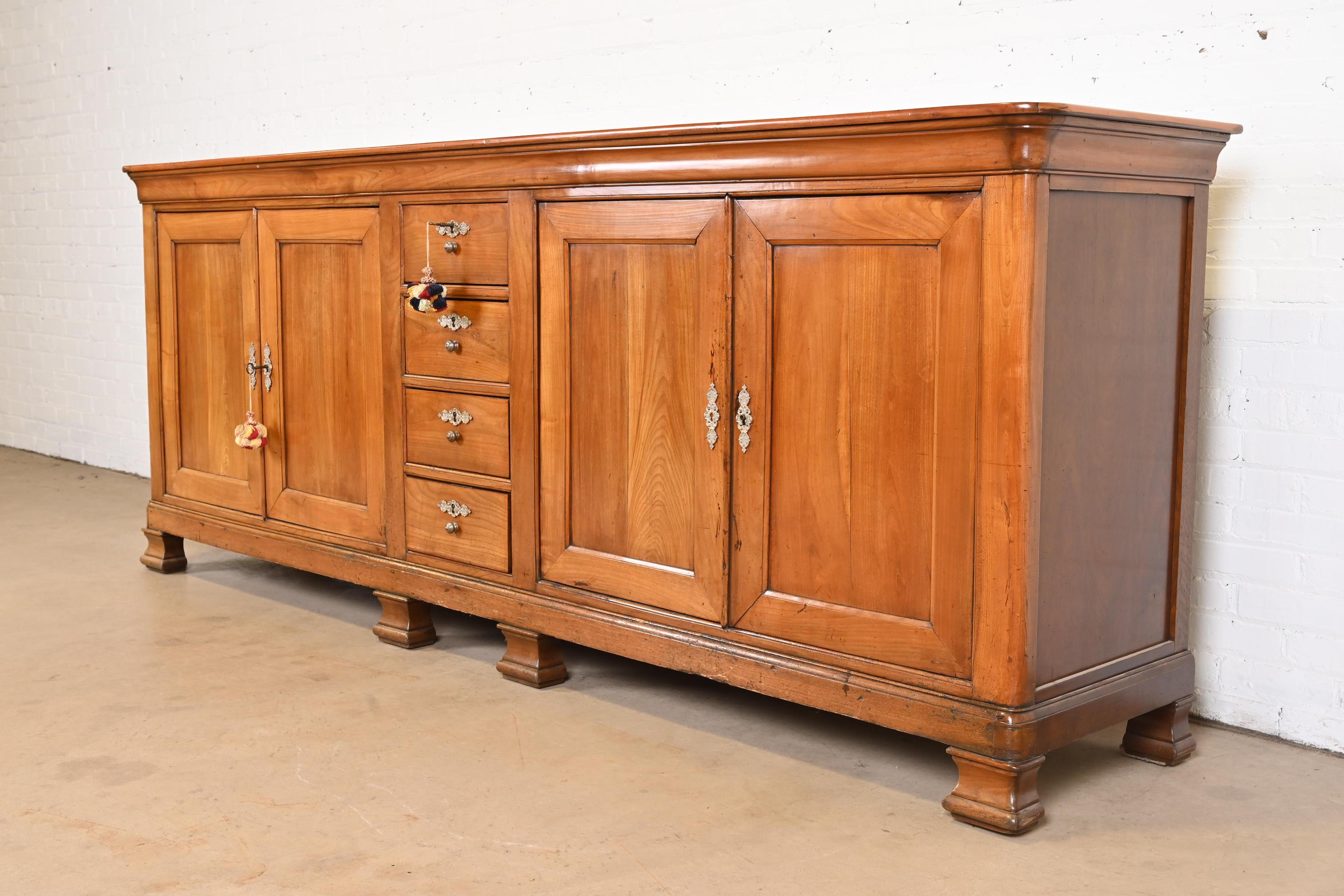 A gorgeous monumental French Provincial or Louis Philippe sideboard buffet, credenza, or bar cabinet

France, late 19th century

Carved walnut, with original brass hardware. Cabinets and drawers lock, and two keys are included.

Measures: