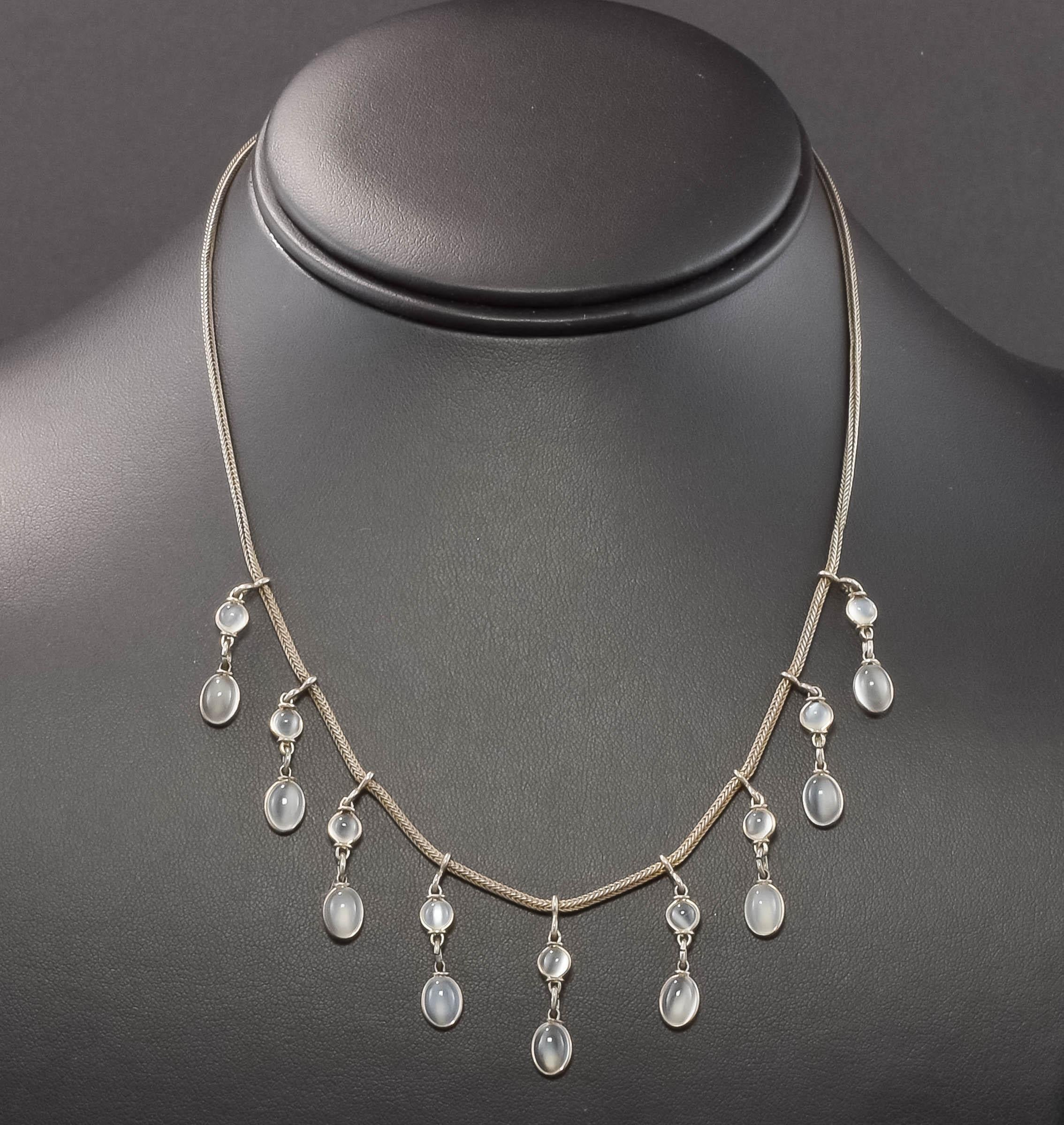 Dating to the Arts & Crafts period (1890 - 1910), this dainty and ethereal antique Moonstone Droplet Necklace was found in a New England Estate.

Crafted of silver testing around sterling standard, the necklace features a total of 18 petite silvery