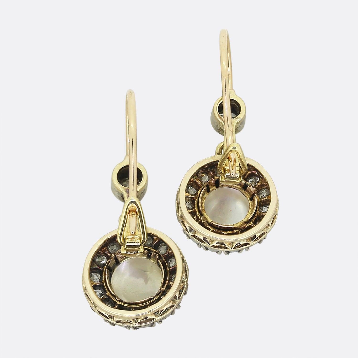 Here we have a lovely pair of moonstone and diamond drop earrings that date back to the Victorian era. The cabochon moonstones are surrounded by 14 old cut diamonds and there is a single old cut diamond set at the top. They feature a French hook