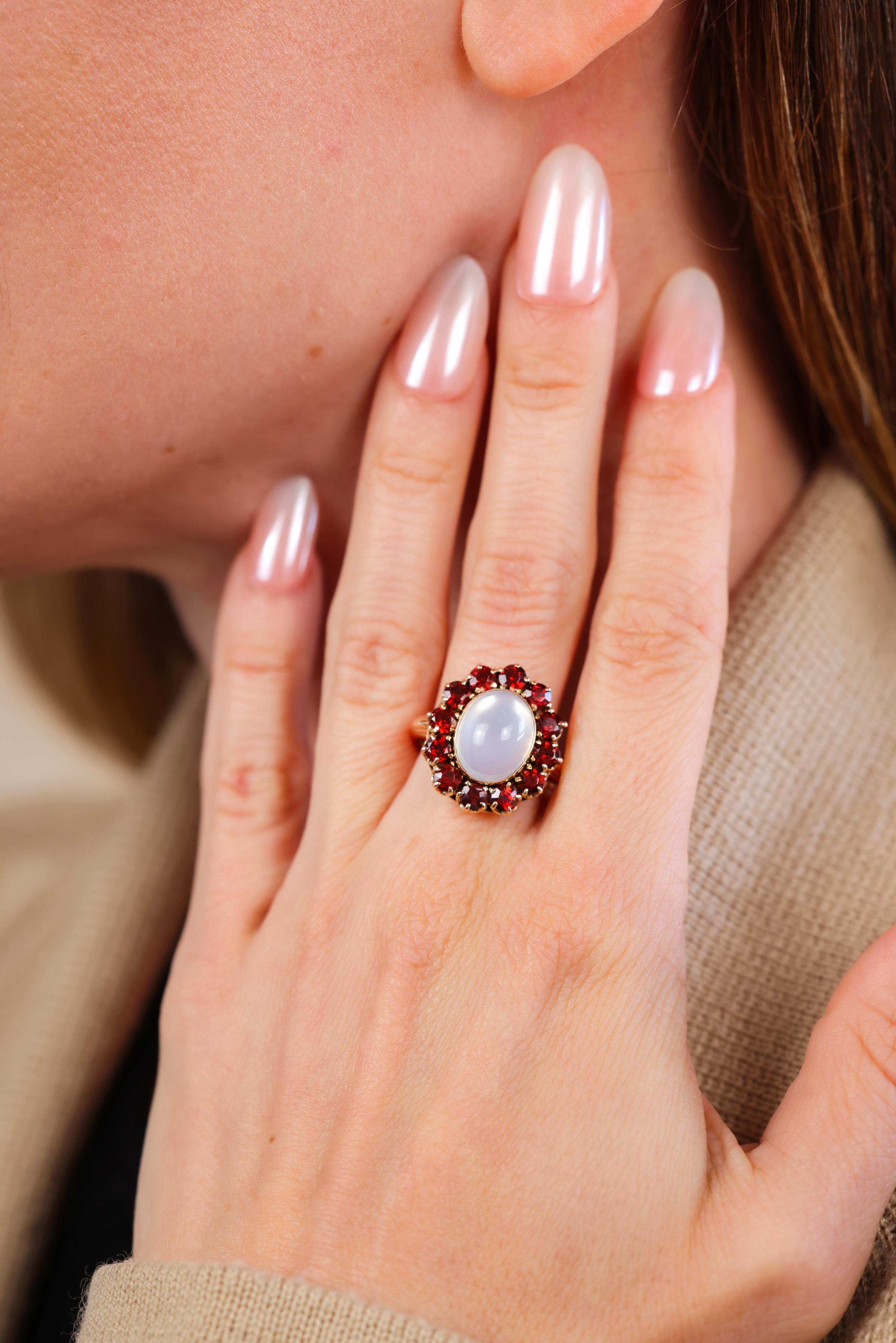 5.2 carat cabochon cut moonstone
12 fiery orangey-red round cut garnet weighing approx 3.5 carats
14k yellow gold 
Victorian circa 1890 
Ring size 8-1/4 and can be resized
6.7 grams

This exquisite Victorian ring from circa 1890 is a breathtaking