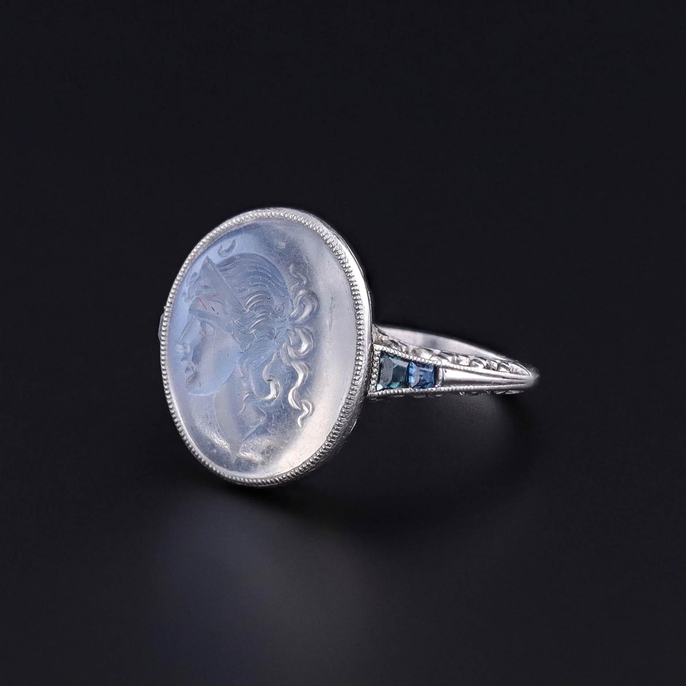Antique Moonstone Ring: A striking antique moonstone intaglio ring depicting the Greek goddess Selene (Roman goddess Luna). The intaglio is mounted in platinum with calibre cut sapphires on the shoulders of the band.

The face of the ring measures