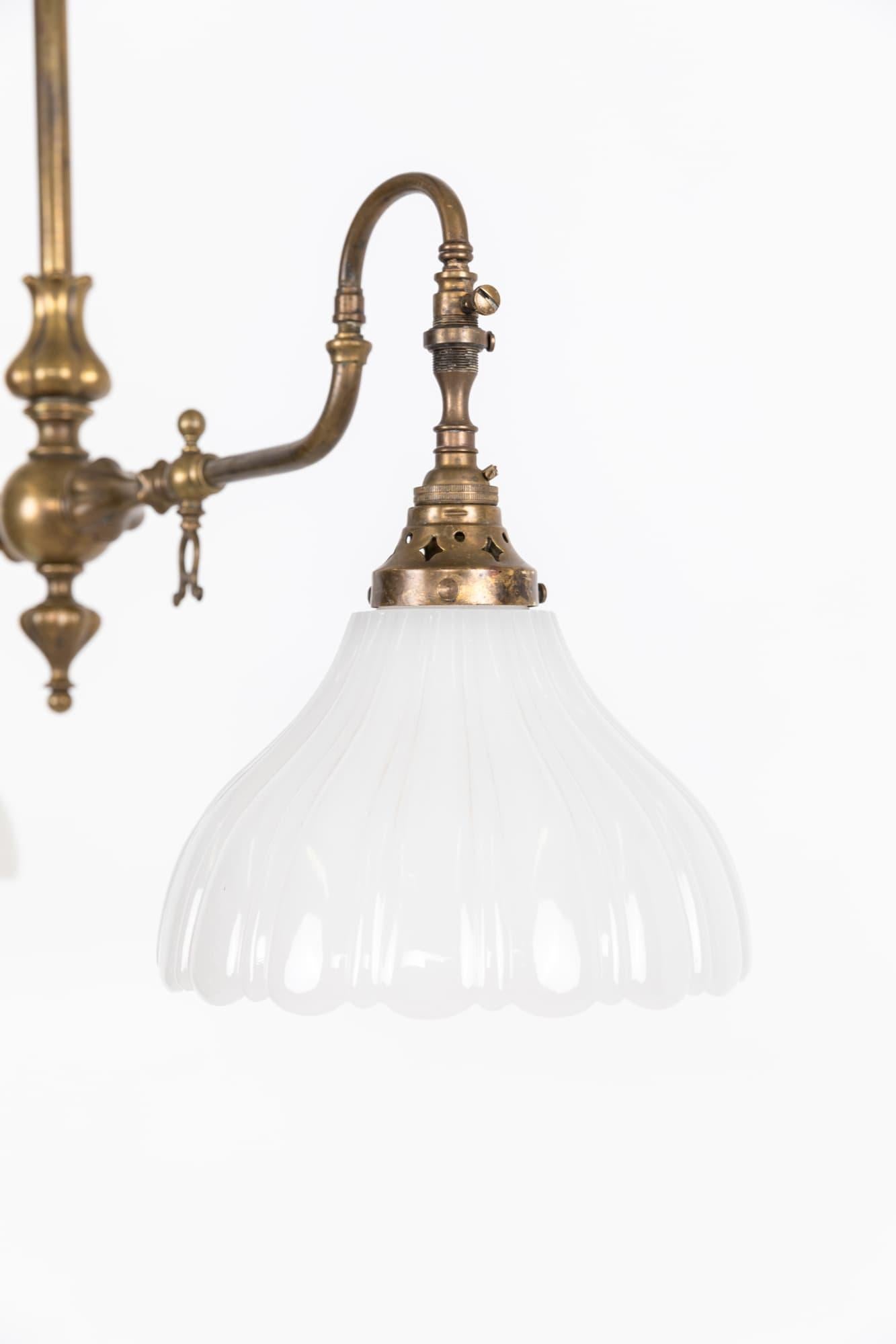 

An elegantly formed brass gasolier with pressed moonstone glass shades. c.1920

Beautifully designed former two-branch gasolier, now converted to electric. Central stem mounts directly to the ceiling.
