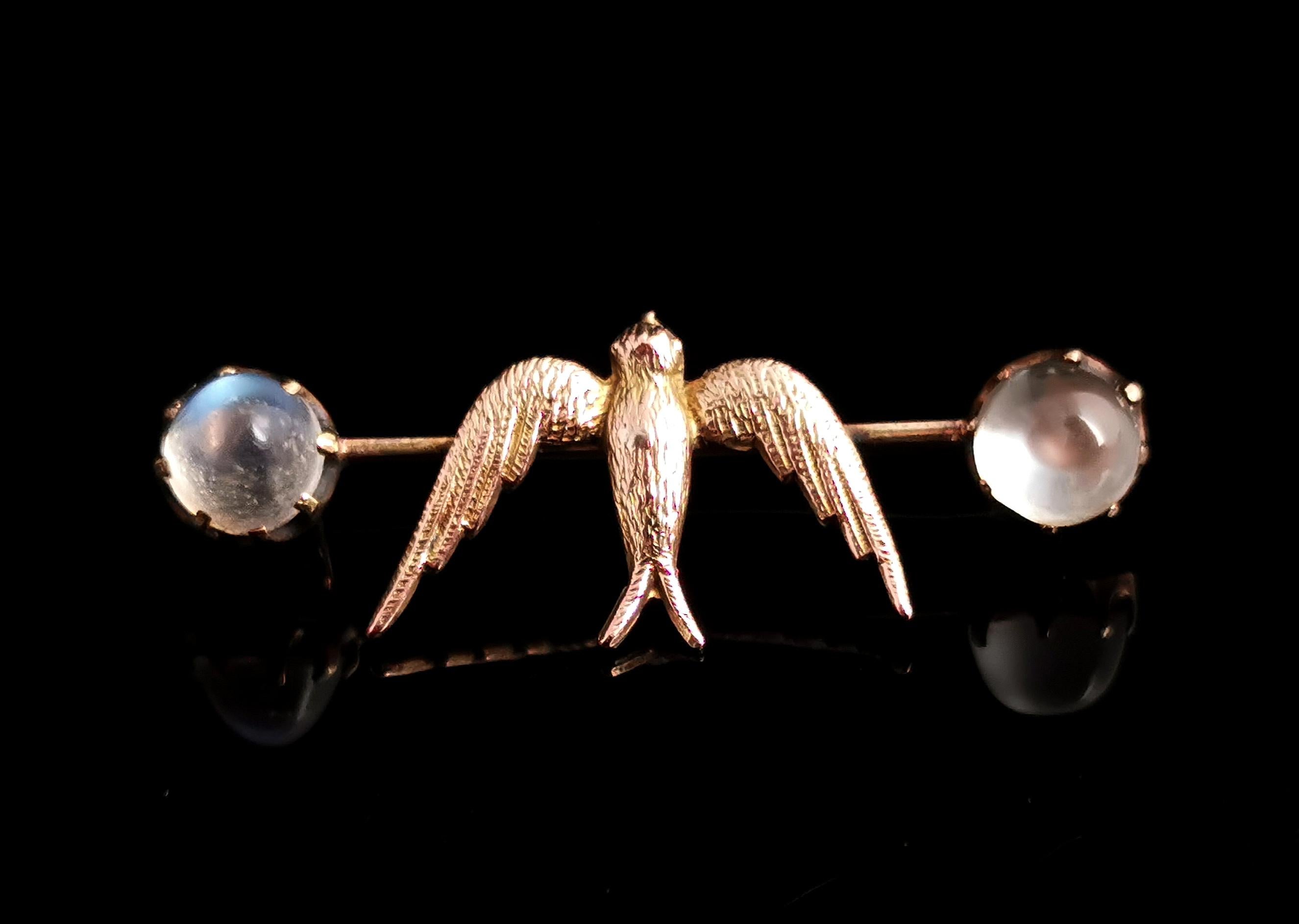 A beautiful antique, Edwardian Moonstone Swallow brooch or pin.

A slim 12kt yellow gold bar set with a rich textured golden Swallow bird in flight.

The Swallow is shouldered each side by a magical glowing moonstone cabochon, each claw set in a