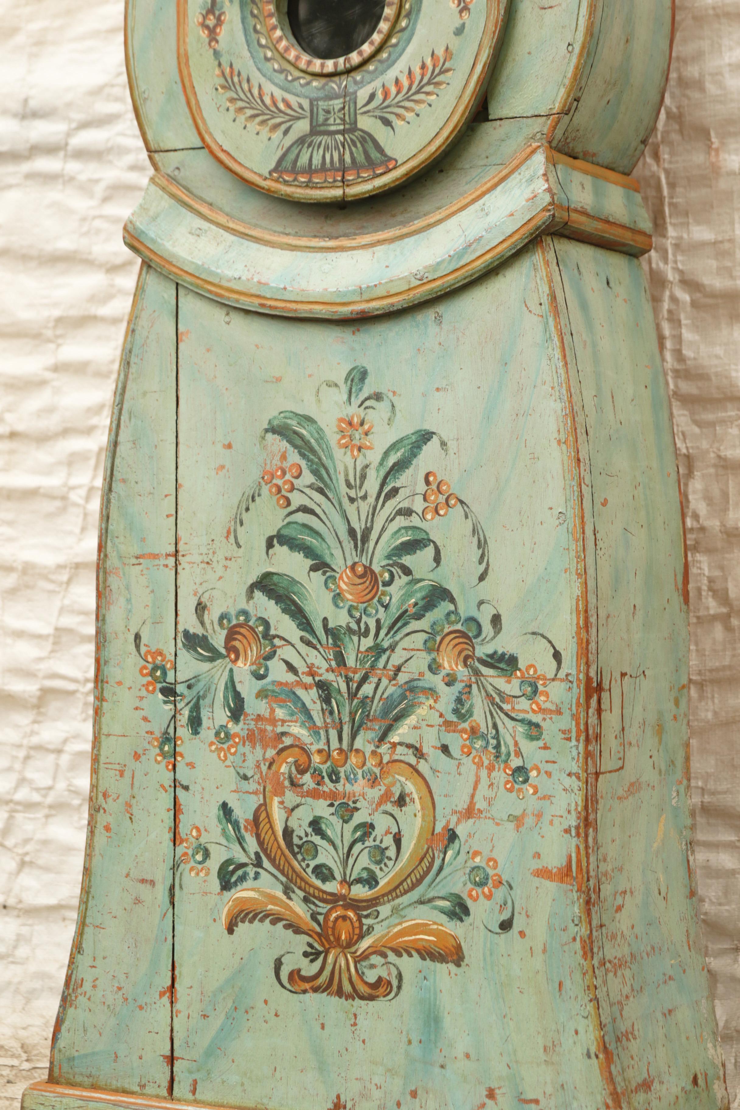Antique Swedish Mora clock in green with hand painted floral details and clockmakers initials on face AAL and twon where the clock was made 'Mora'. Working Longcase clock mechanism of pendulum and 2 weights and a bell chime on the hour.

Width: 42cm