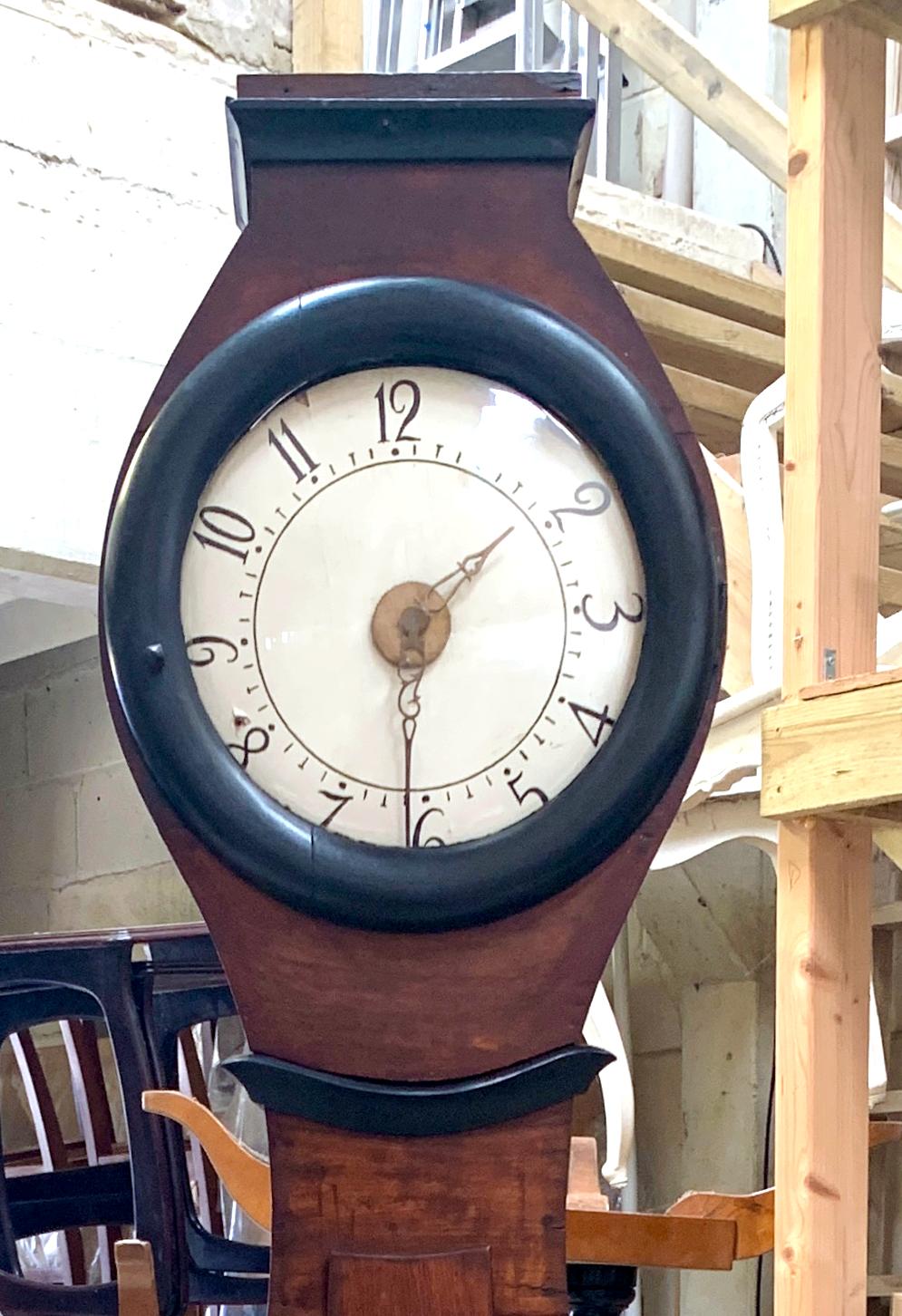 Antique Swedish mora clock from early 1800s in natural finish and with a great waisted shape body and a good face with lots of detail with ormolu style accents. Measures: 210cm.

It has the Classic extended belly of a traditional Swedish mora clock.