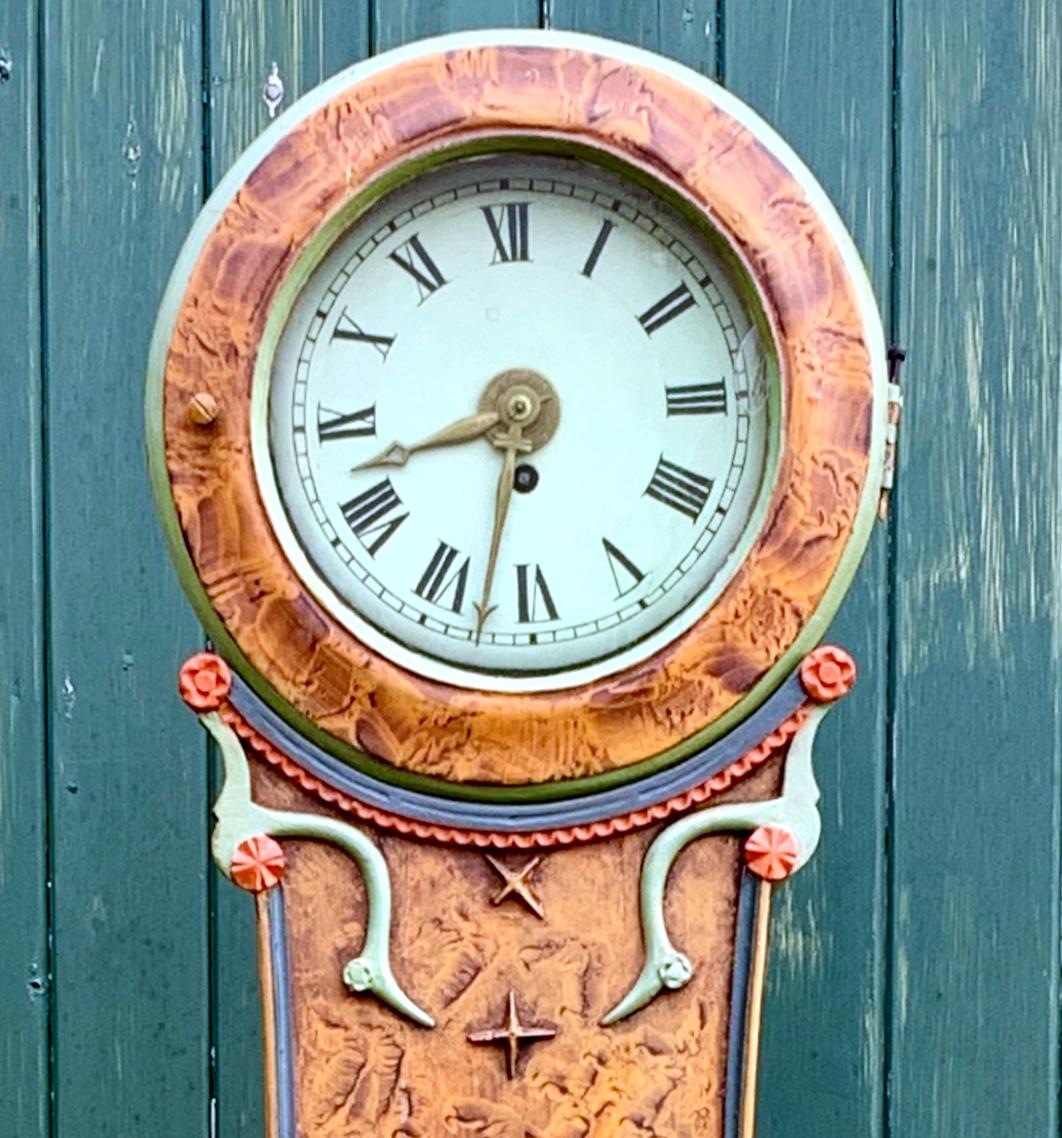 Antique Swedish mora clock from the early 1800s in amazing hand painted folk art kurbits finish and classic Fryksdall detailing with an extended belly shape body and a clean face in good condition with roman numerals. Measures: 200 cm.

It has the