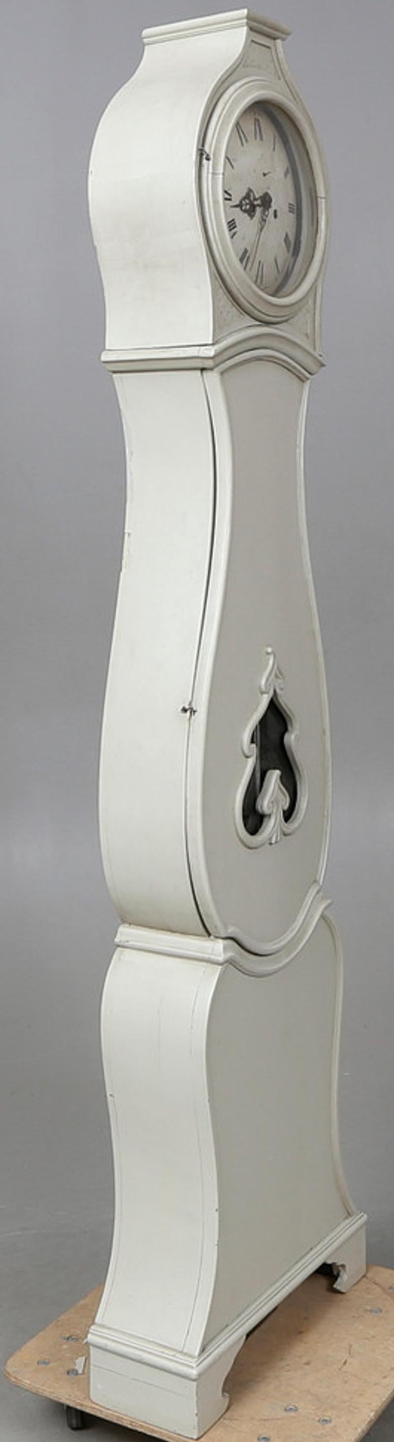 Horloge mora suédoise ancienne du début des années 1800 avec une belle finition gris blanc et une fenêtre de pendule unique en forme de feuille avec un corps allongé en forme de ventre, une couronne et des détails simples et un cadran de chiffres