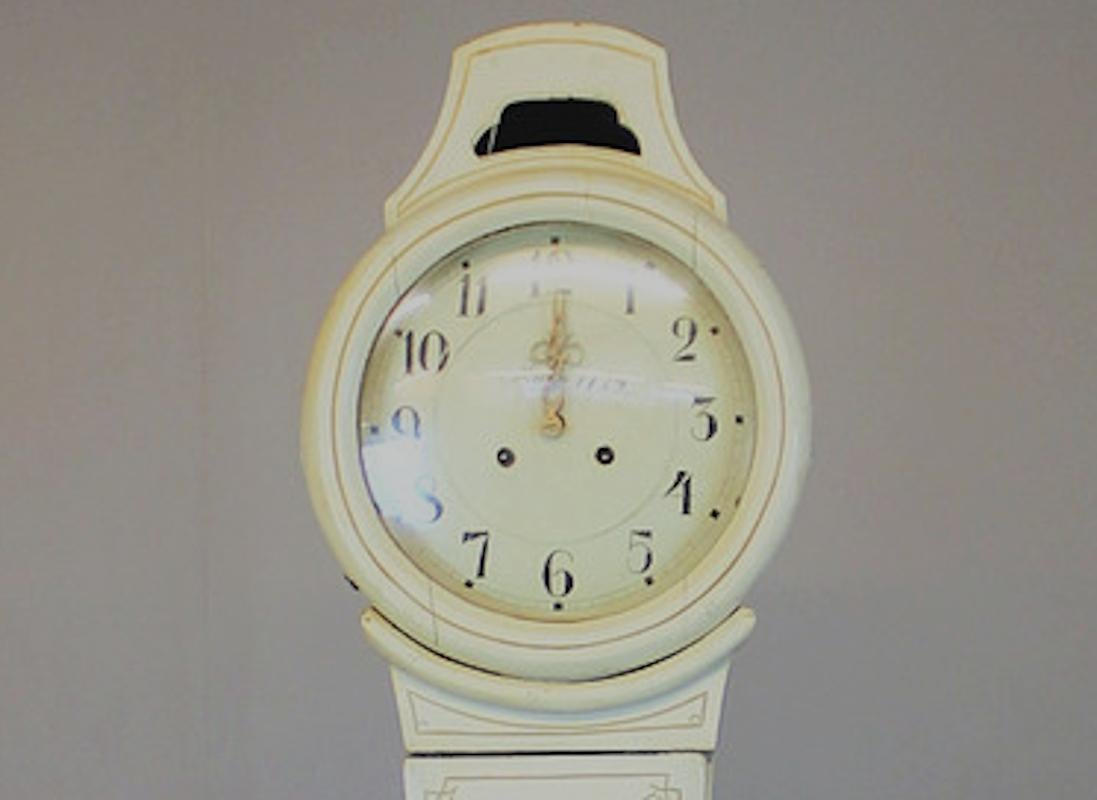 Antique Swedish mora clock from the early 1800s in white paint finish and simple detailing with an extended belly shape body and a rclean face in good condition. Measures: 206 cm.

It has the classic extended belly of a traditional Swedish mora