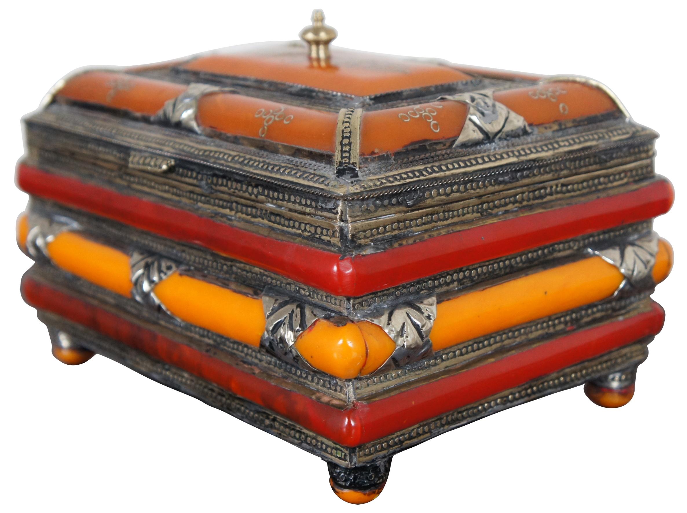 Antique red / amber and orange / butterscotch, and silver bakelite jewelry / trinket casket featuring stamped silver overlay, black velvet lining and footed base. Measure: 8