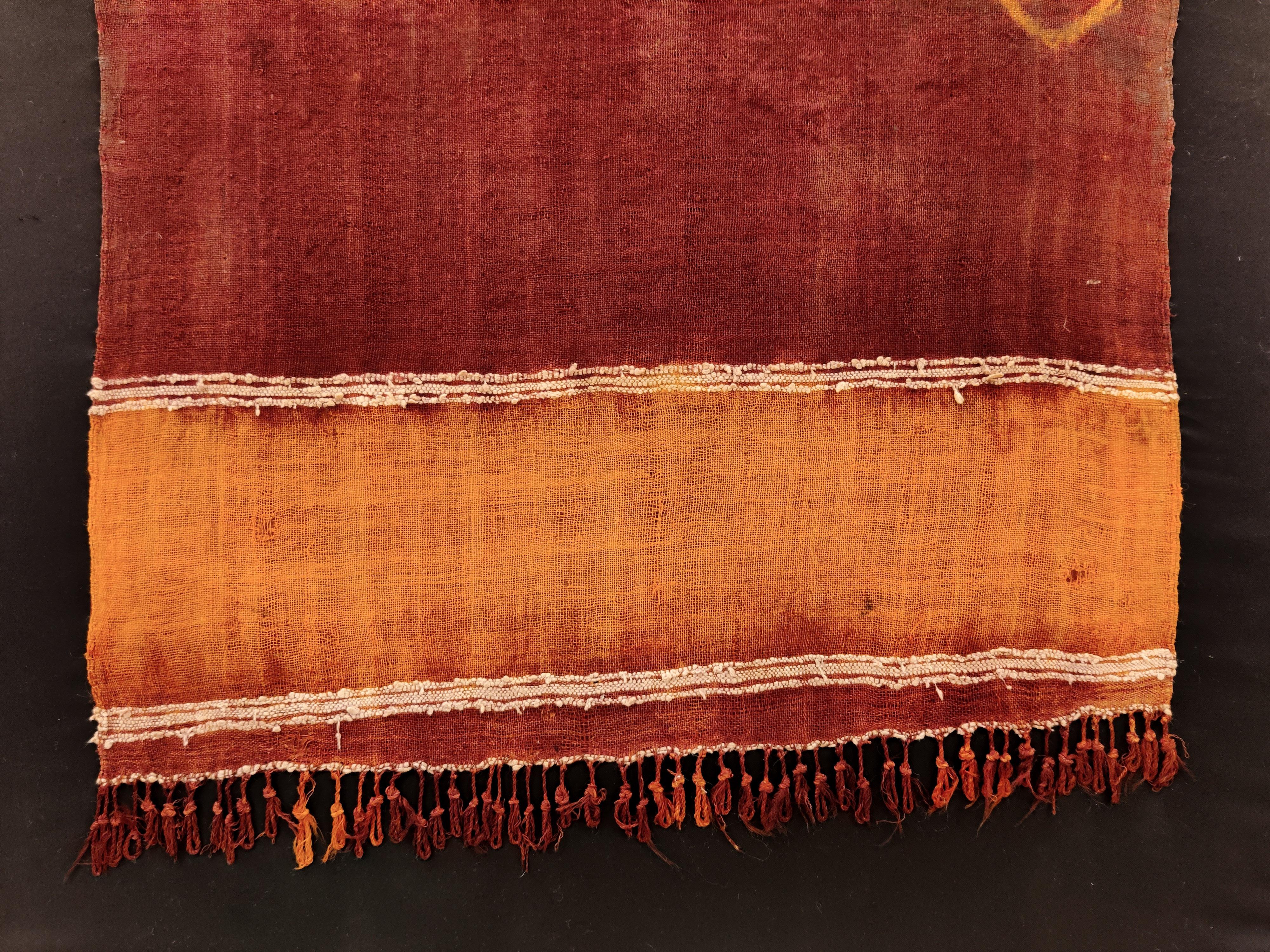A very finely woven wool veil of an unusual format, with a design composed of three small circles set against an open field background, sparsely embellished with touches of embroidery in white cotton. Veils such as these are called takenboukht, and