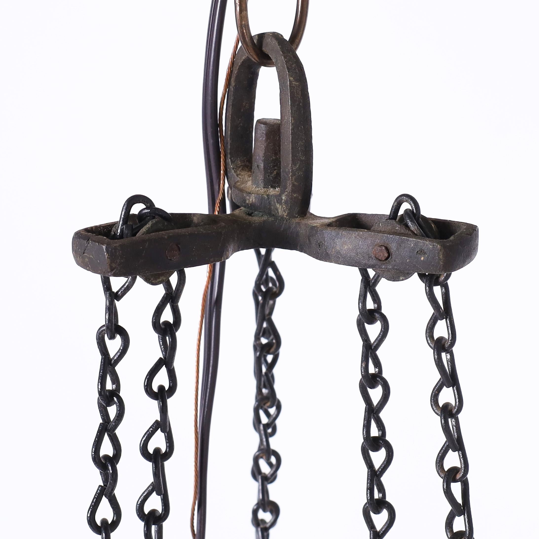 Altivo y exótico farol marroquí o aplique de luz colgado de las seis cadenas originales, fabricado en latón perforado y labrado de forma morisca clásica, con una pátina similar al bronce y vidrieras verdes y rojas. 