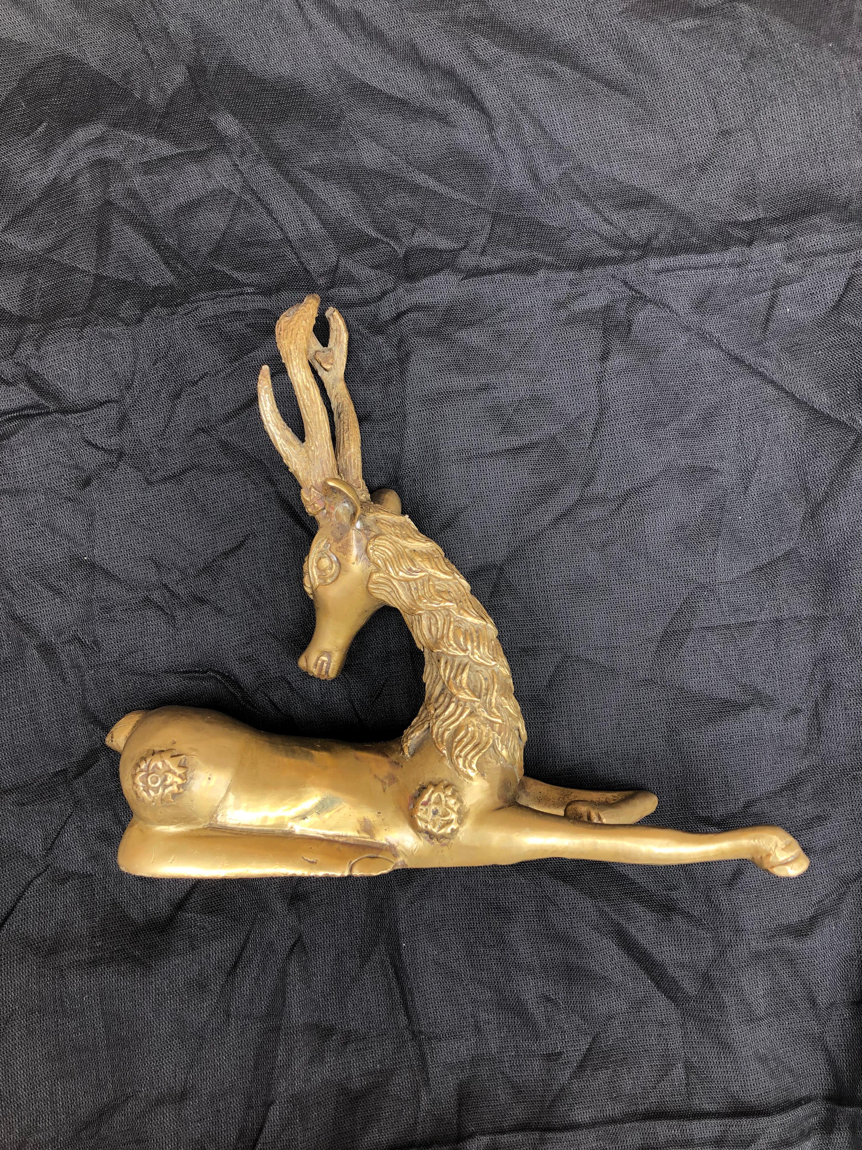 The antique brass gazelle was sourced in the ancient city of Fes, Morocco. Completely handcrafted, with beautiful detailed embossing. The manner in which this is crafted and symbols found on the gazelle date this item in the late 1800s-early