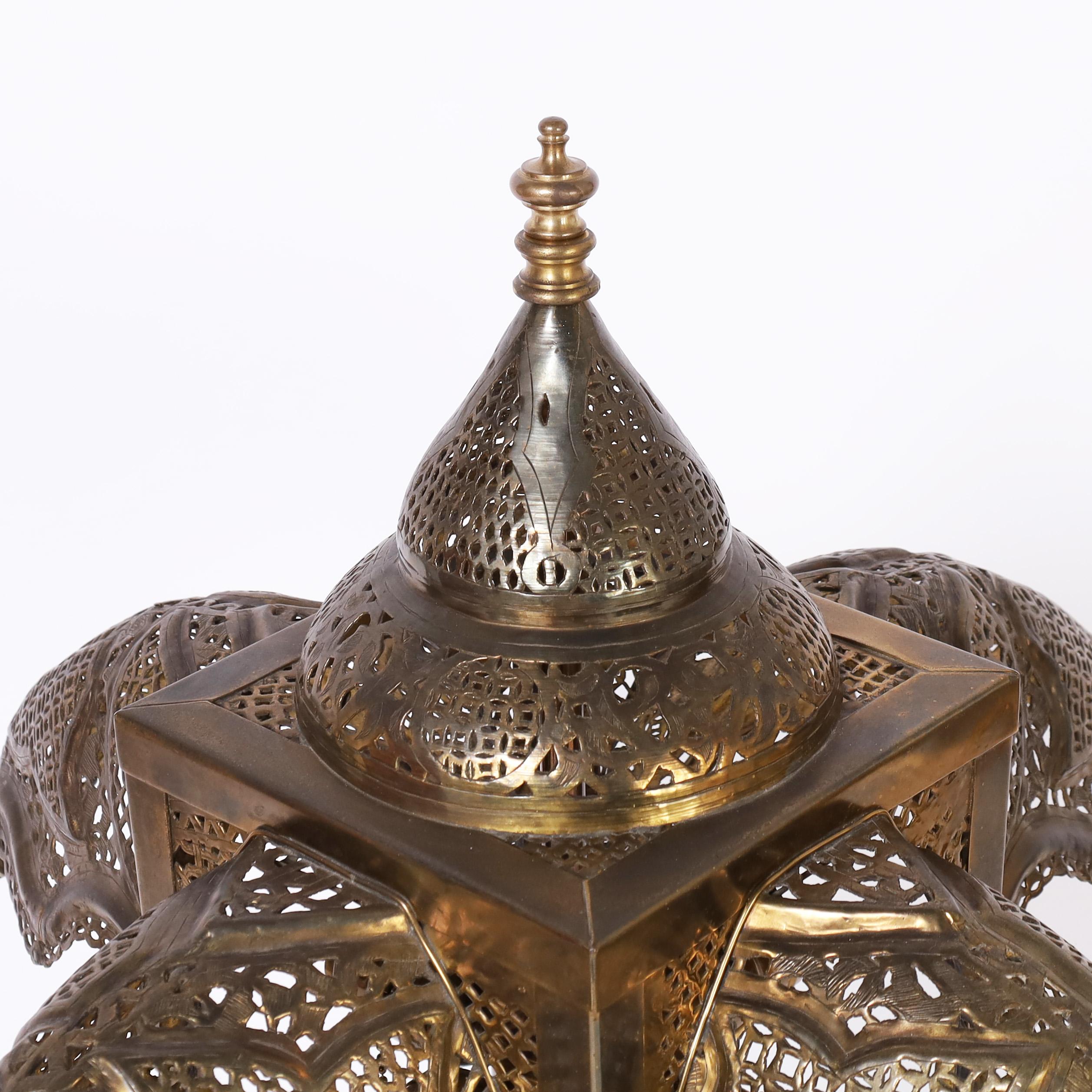 Incantevole lampada da tavolo marocchina antica di grandi dimensioni realizzata a mano in ottone perforato con un paralume a cupola e quattro parti su una base dalla classica forma a clessidra. 