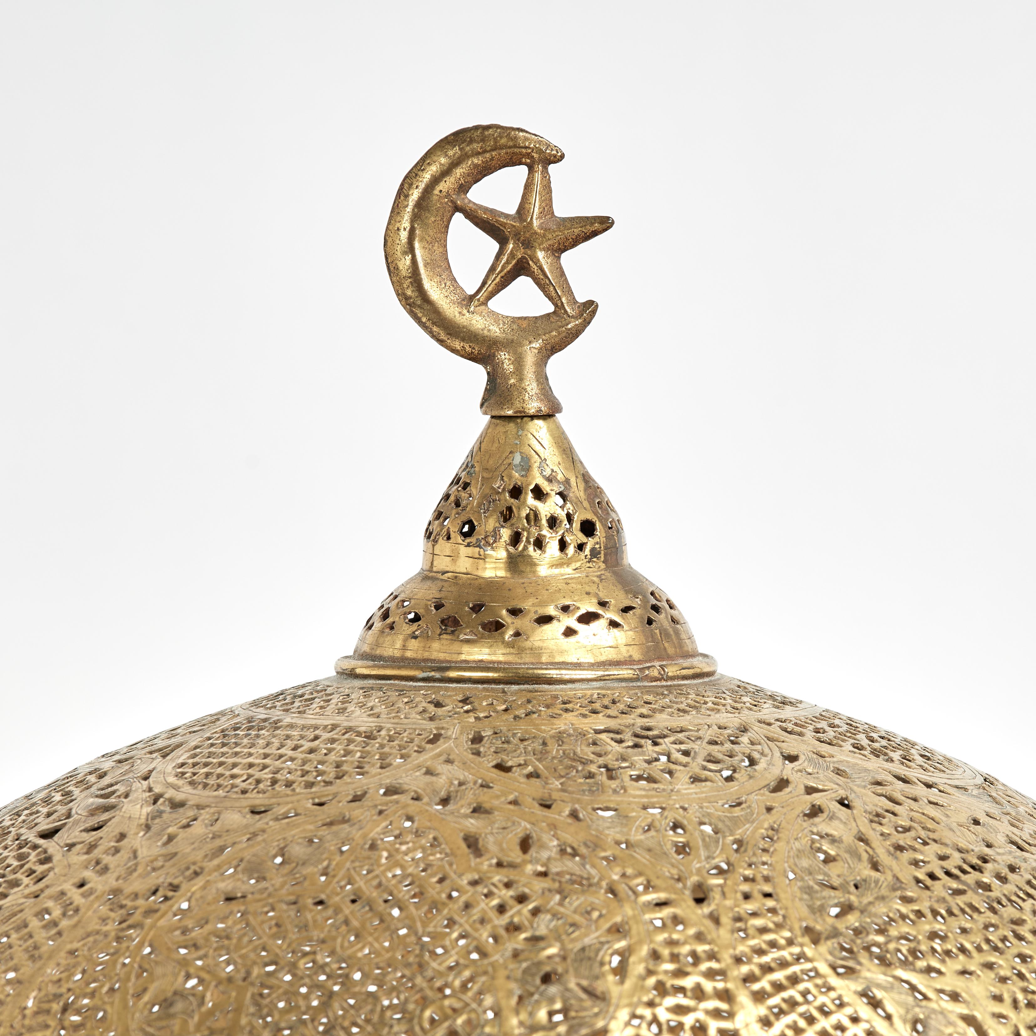Charmante lampe de table orientale marocaine ancienne, fabriquée en laiton, avec un croissant de lune et un fleuron étoilé pour la guidance spirituelle, sur un abat-jour et une base perforés de motifs symboliques.