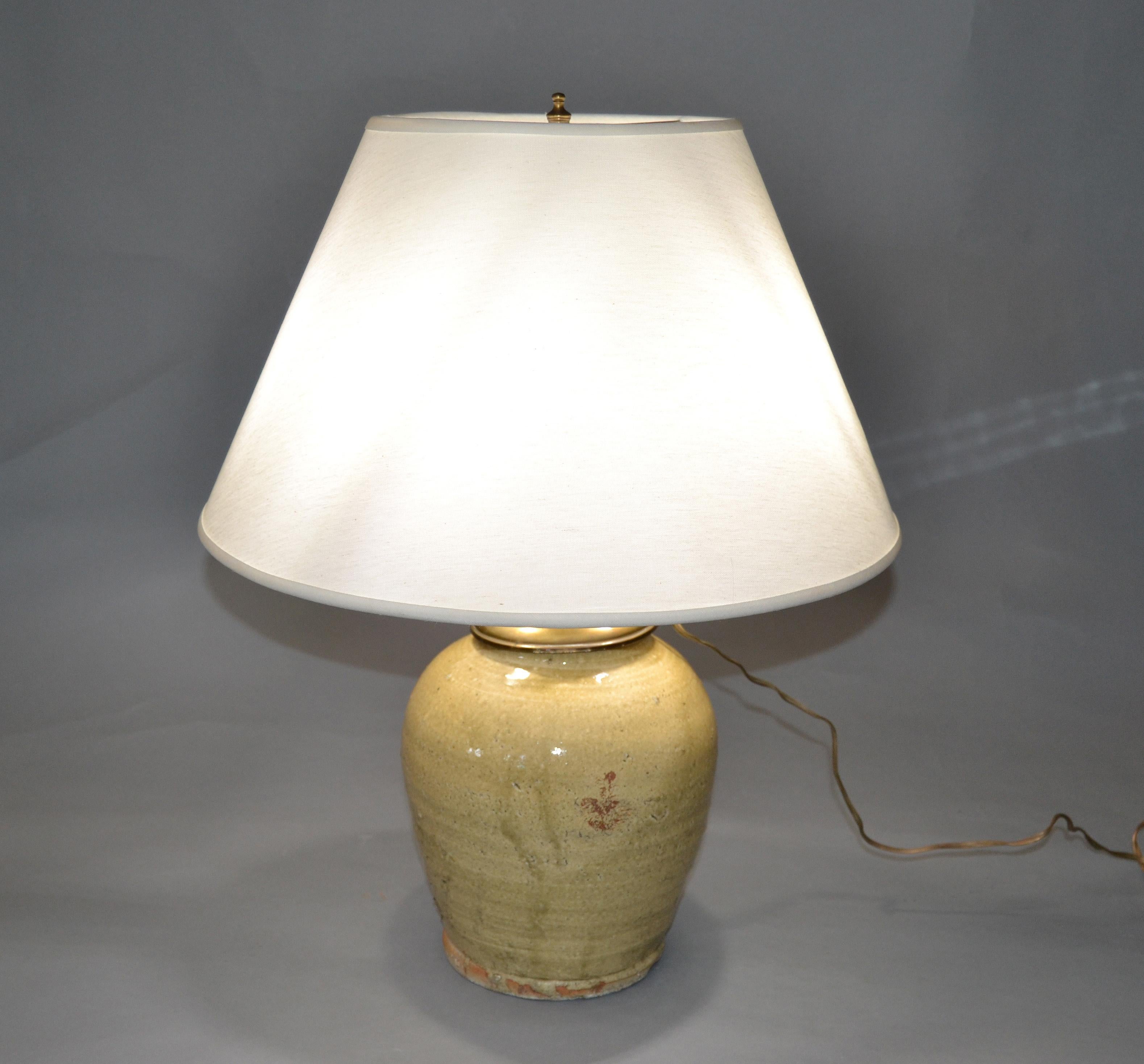 This table lamp has a glazed terracotta core and is topped with a brass shaft and double sockets.
Wiring for the US and takes two regular light bulbs with 40 watts each. 
In perfect working condition.
Note this item is handcrafted and has no felt