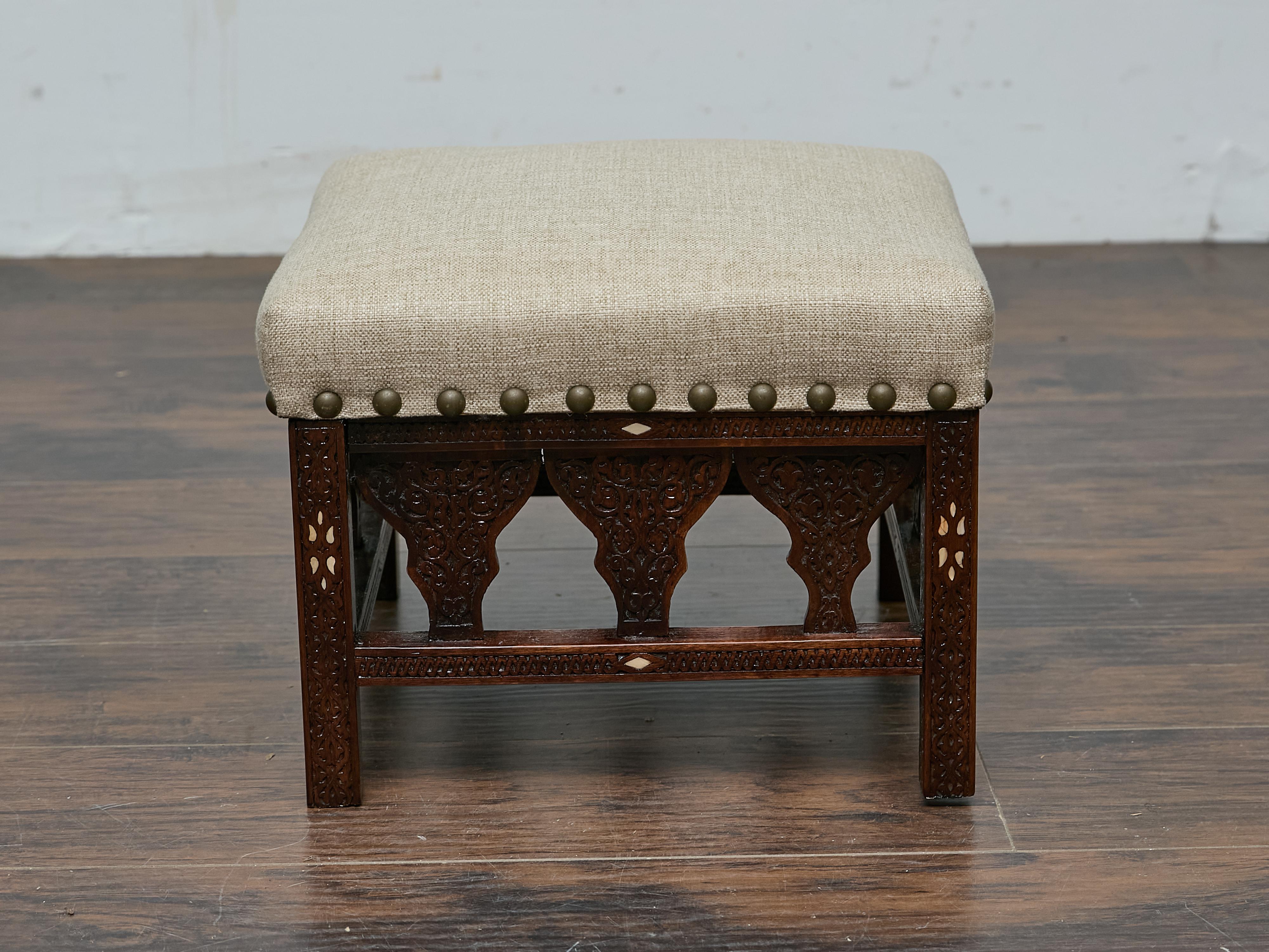 Ce tabouret marocain datant de 1900 présente des détails complexes sculptés à la main et des incrustations d'os délicates, créant un contraste saisissant avec le bois riche. Les motifs géométriques et arabesques reflètent l'art marocain