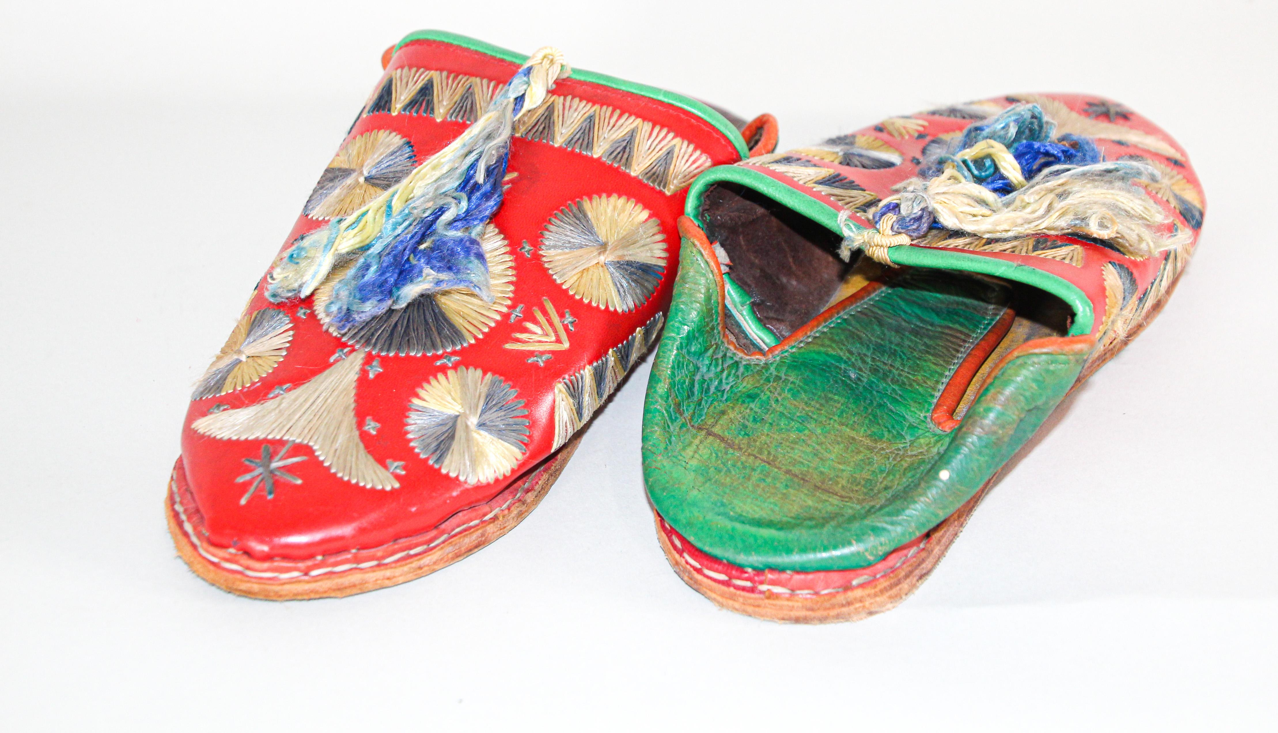 Antique Moroccan leather slippers, known as babouches are handmade from leather dyed in red and green and embroidered in silk wool thread with ethnic floral design, hand-sewn sole.
Hand-tooled traditional Moroccan shoes in Tangier North of