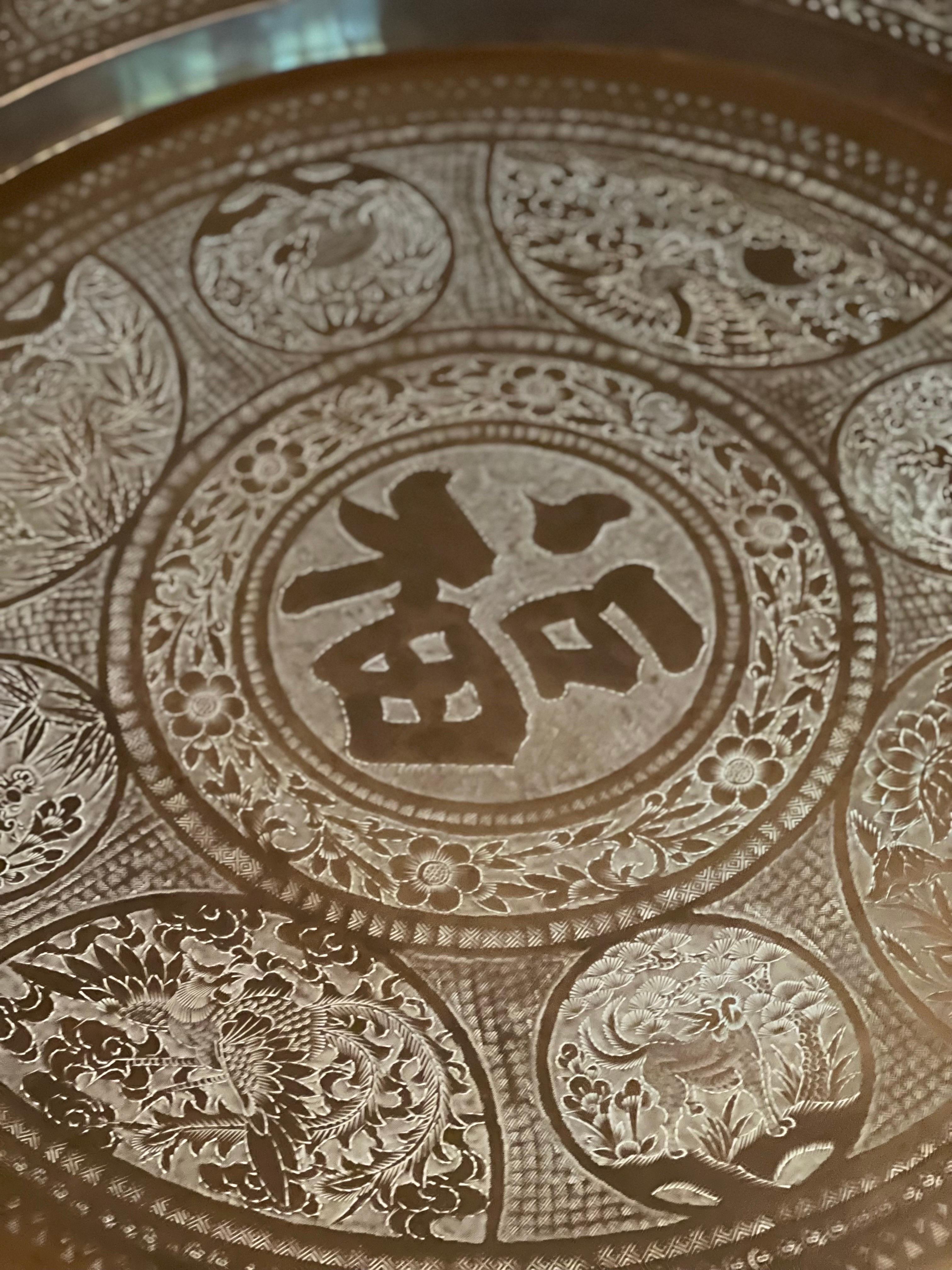 Antiker indo-persischer, handgefertigter Tisch aus gehämmertem Messing. Das Tablett ist mit verschiedenen handgeschnitzten Blumen- und Tiermotiven in arabischer Kalligraphie verziert. 

Das Tablett steht sicher auf einem faltbaren Sockel aus Metall