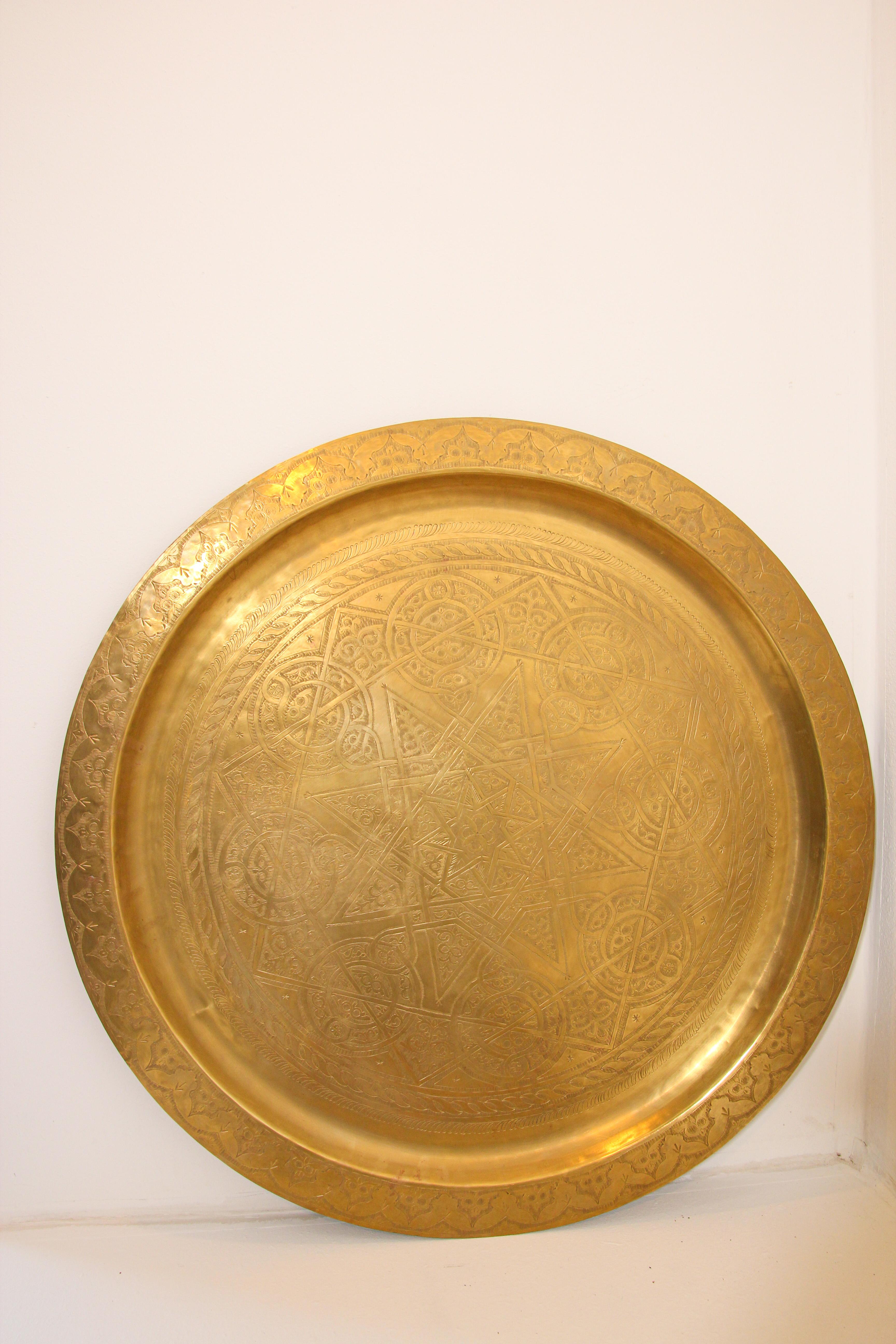 Antique Moroccan large metal polished round brass tray platter.
Polished decorative metal brass round tray with very fine intricate designs.
Finely hand-hammered and chiseled in floral and geometrical Moorish designs.
Heavy brass metal circular