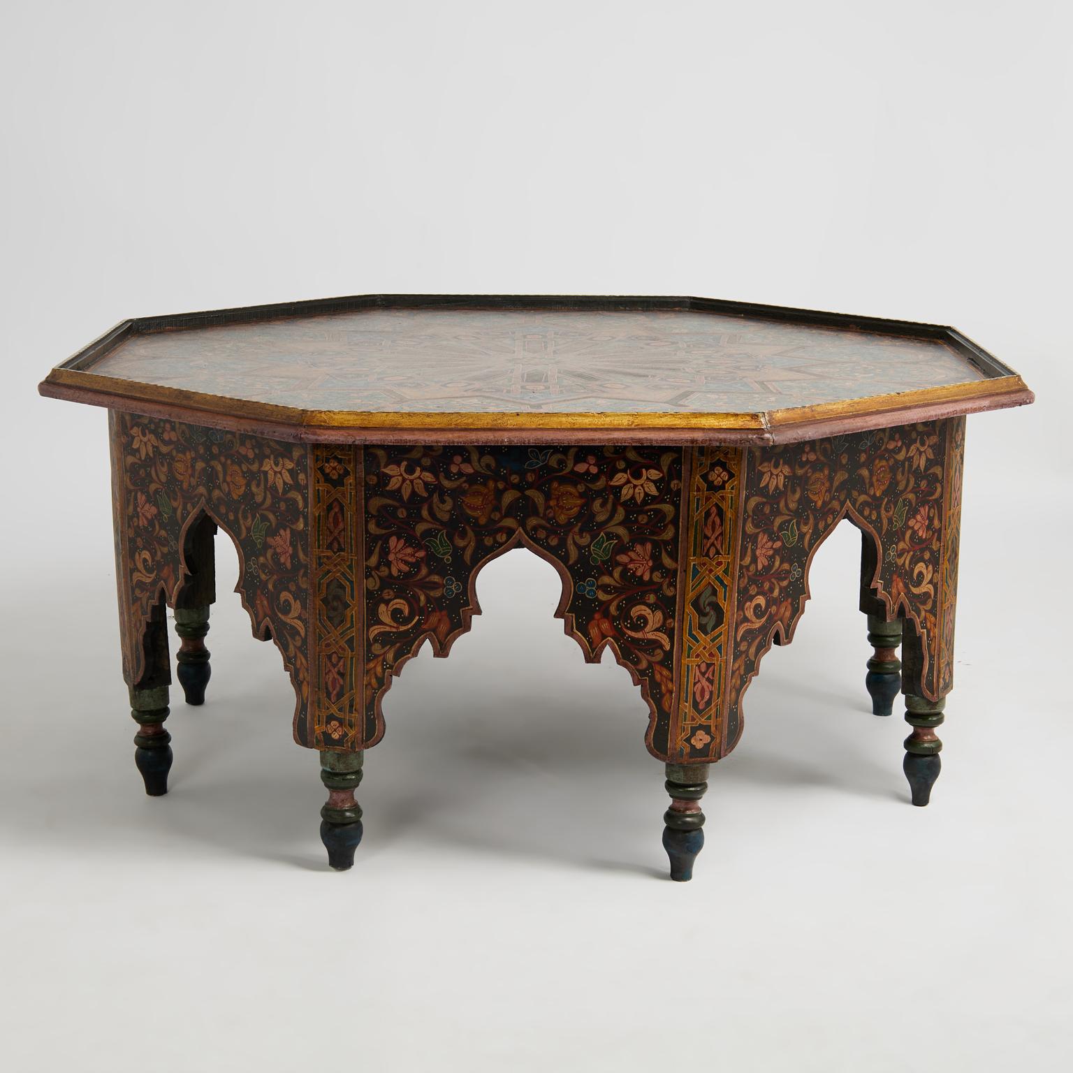 Impressionnante table basse marocaine ancienne, fabriquée à la main en bois dur indigène.  un plateau octogonal décoré à la main de motifs géométriques et floraux élaborés sur une base à huit côtés présentant des arcs mauresques, des peintures