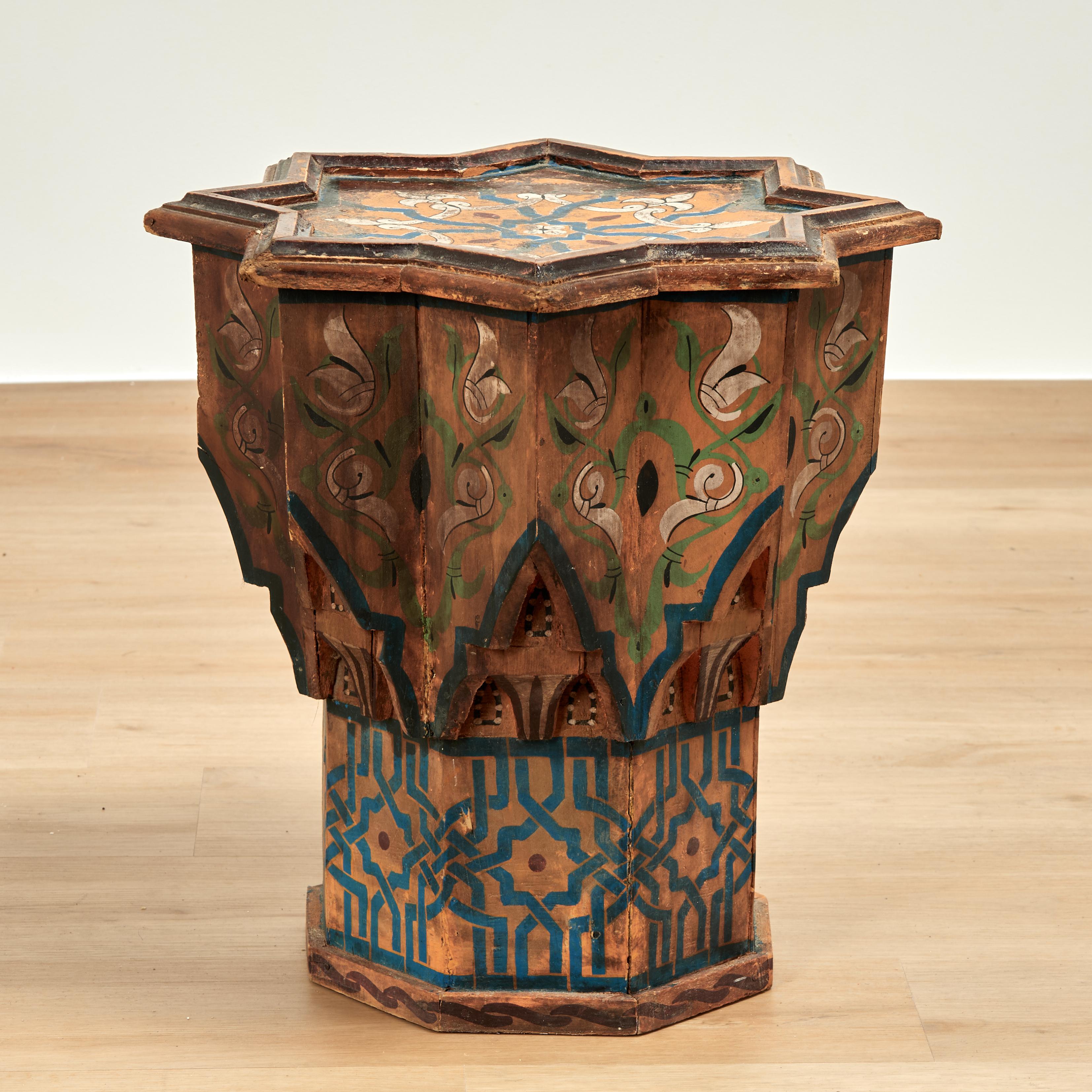 Charmanter antiker marokkanischer Ständer aus einheimischem Hartholz in Sternform, handbemalt mit floralen und geometrischen Motiven, die im Laufe der Zeit verblasst sind. 