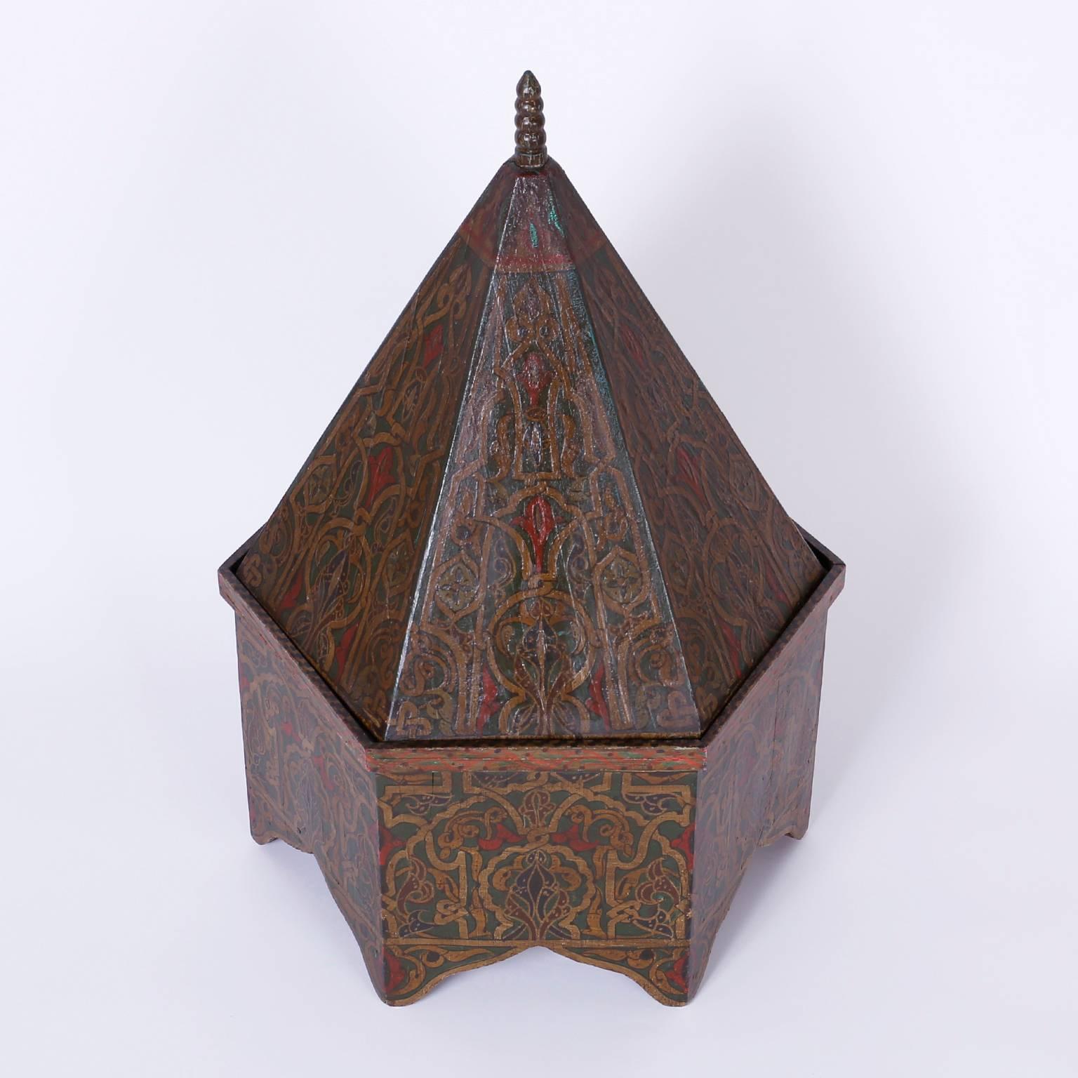 Antique Moroccan wood box painted on all six sides with symbolic floral designs over an architecturally intriguing form and a removable pitched lid.