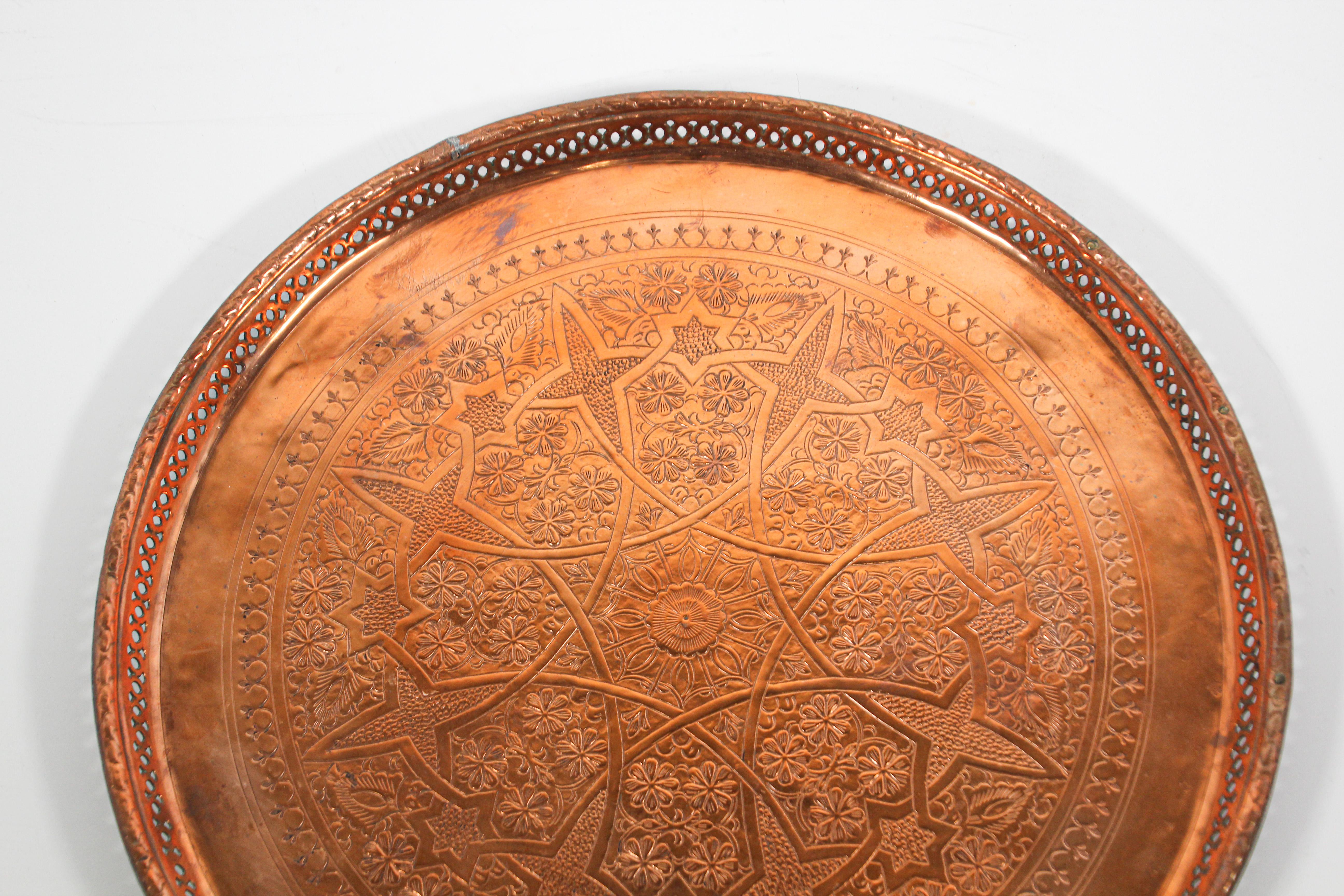 Moroccan antique round copper tray.
The handcrafted circular copper metal platter is decorated and hammered with Islamic Moorish designs.
Heavy red metal plate with very fine hand chased floral and geometric Arabic designs.
Measures: Diameter