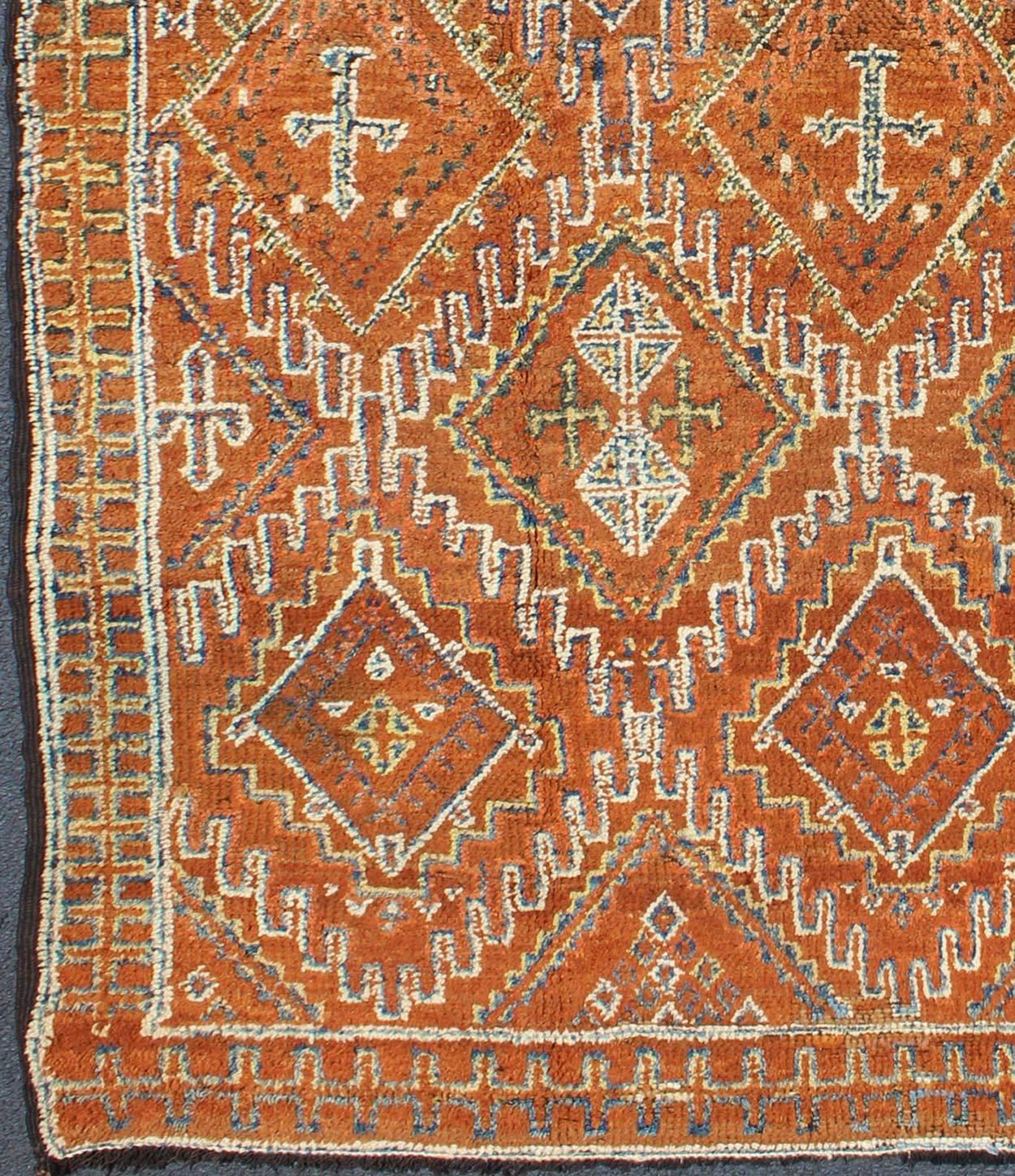This magnificent Moroccan carpet is somewhat rare due to its early age. The rug is constructed with a soft wool pile in a lusciously saturated brown hue. An overall delicate pattern of diamond shapes cover the entire field in various soft colors