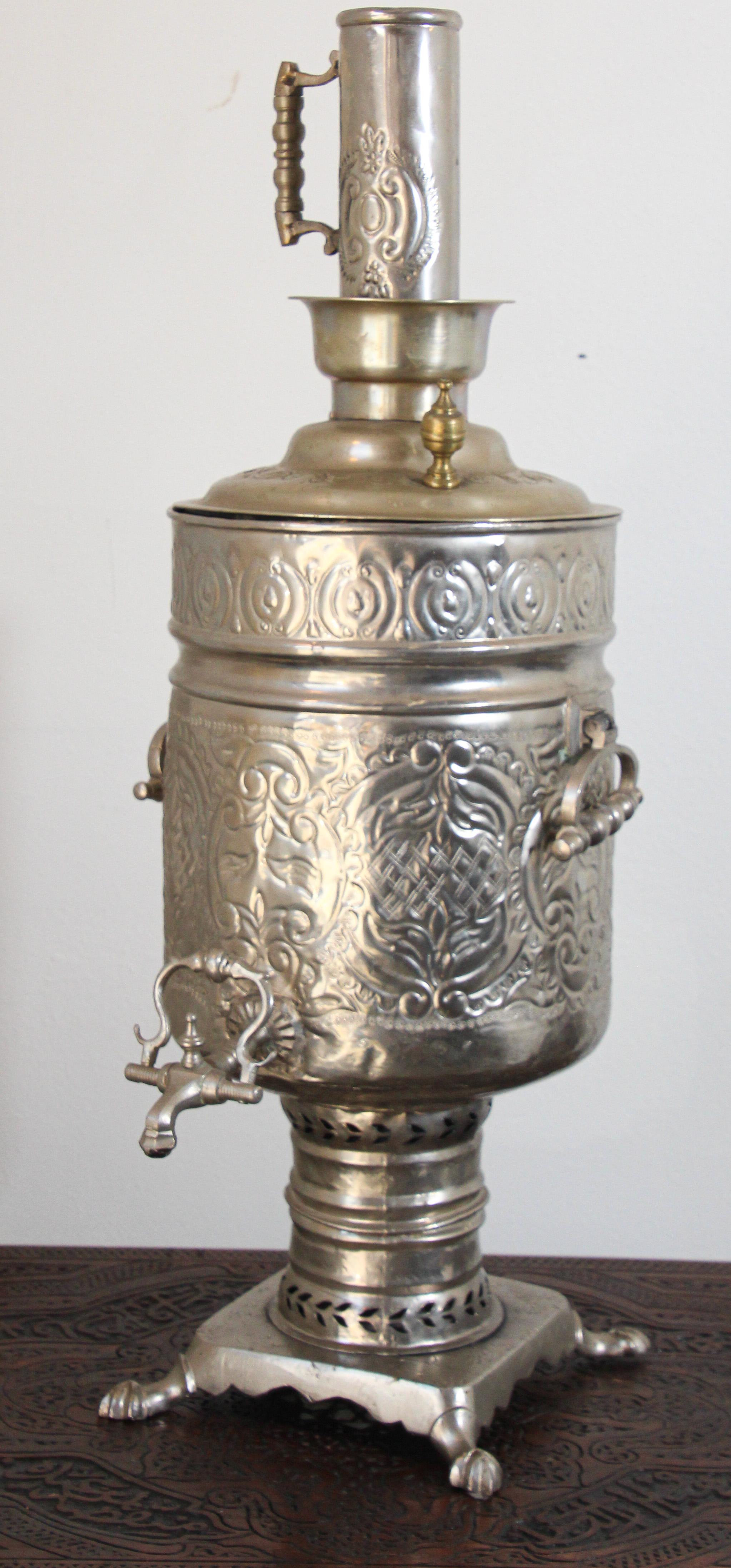 Exceptional hand-crafted Moroccan samovar with etched and embossed floral designs.
Middle Eastern, Islamic style Moorish samovar tea kettle handcrafted in Fez, Morocco.
Brass and silver plated. 
For decoration only.
Measures: Stand is 9