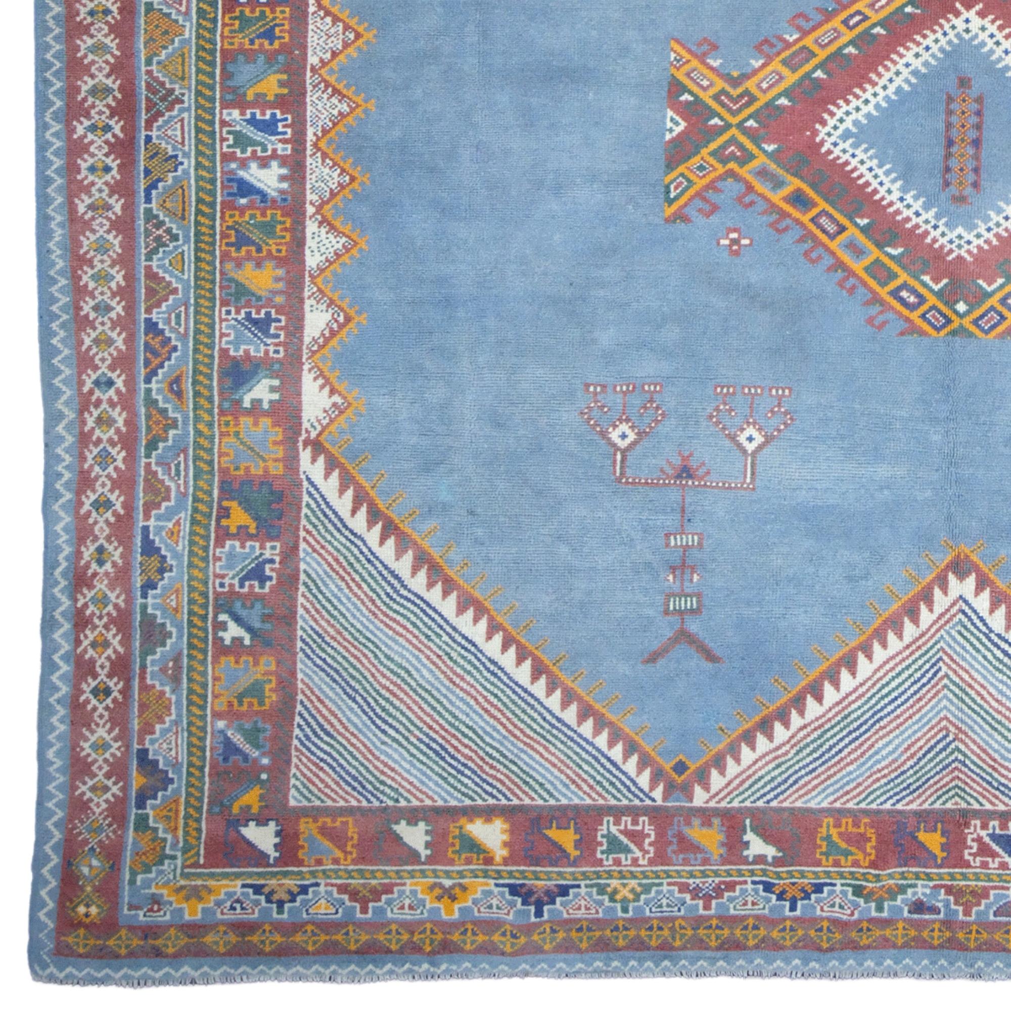 This antique Moroccan carpet dates from the 19th century and has a rich cultural and aesthetic heritage. The carpet is decorated with geometric and traditional Moroccan motifs placed on a blue background. The various colors and complex shapes used