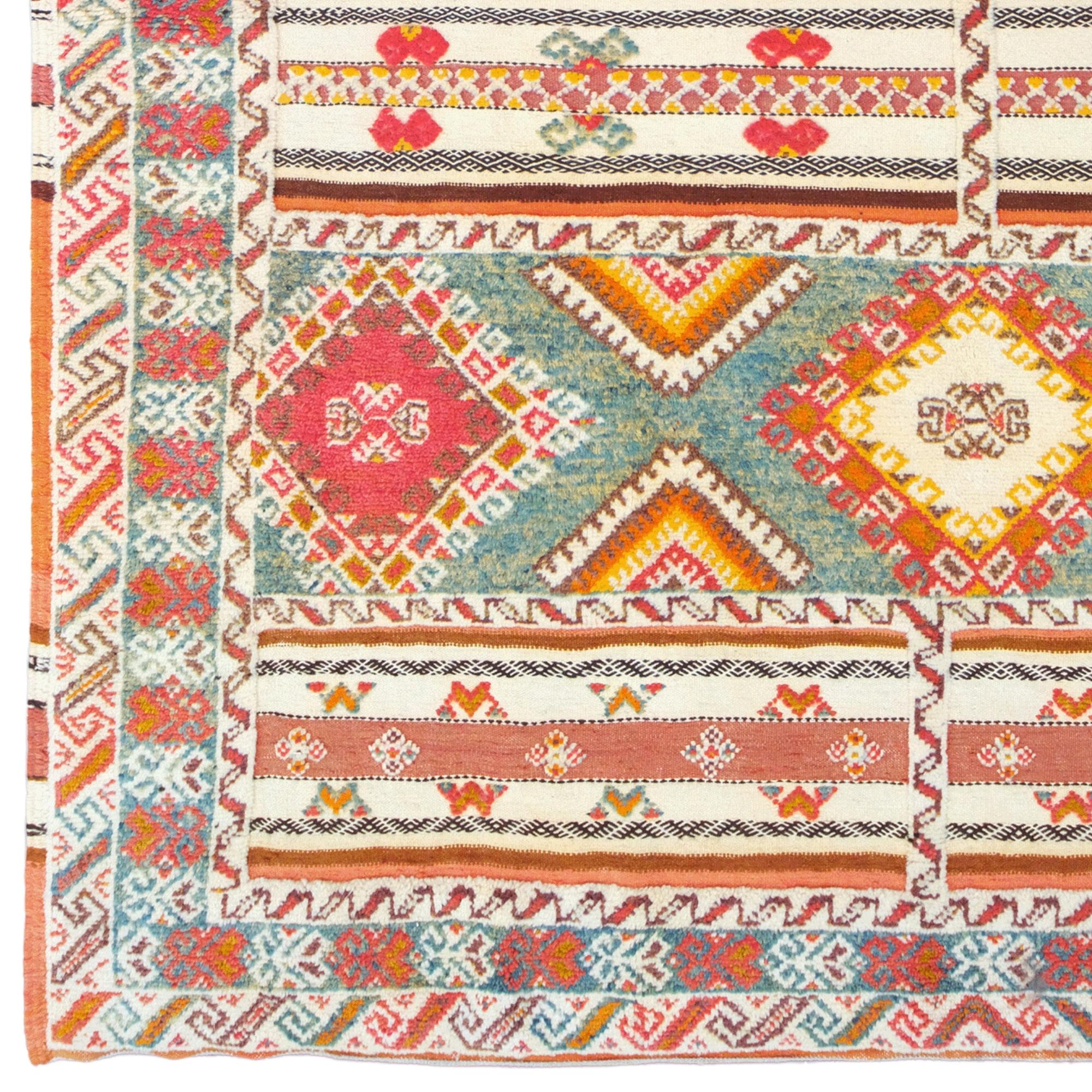 Ce tapis marocain antique date du XIXe siècle et possède un riche patrimoine culturel et esthétique. Le tapis est décoré de motifs géométriques et traditionnels marocains placés sur un fond bleu. Les différentes couleurs et les formes complexes