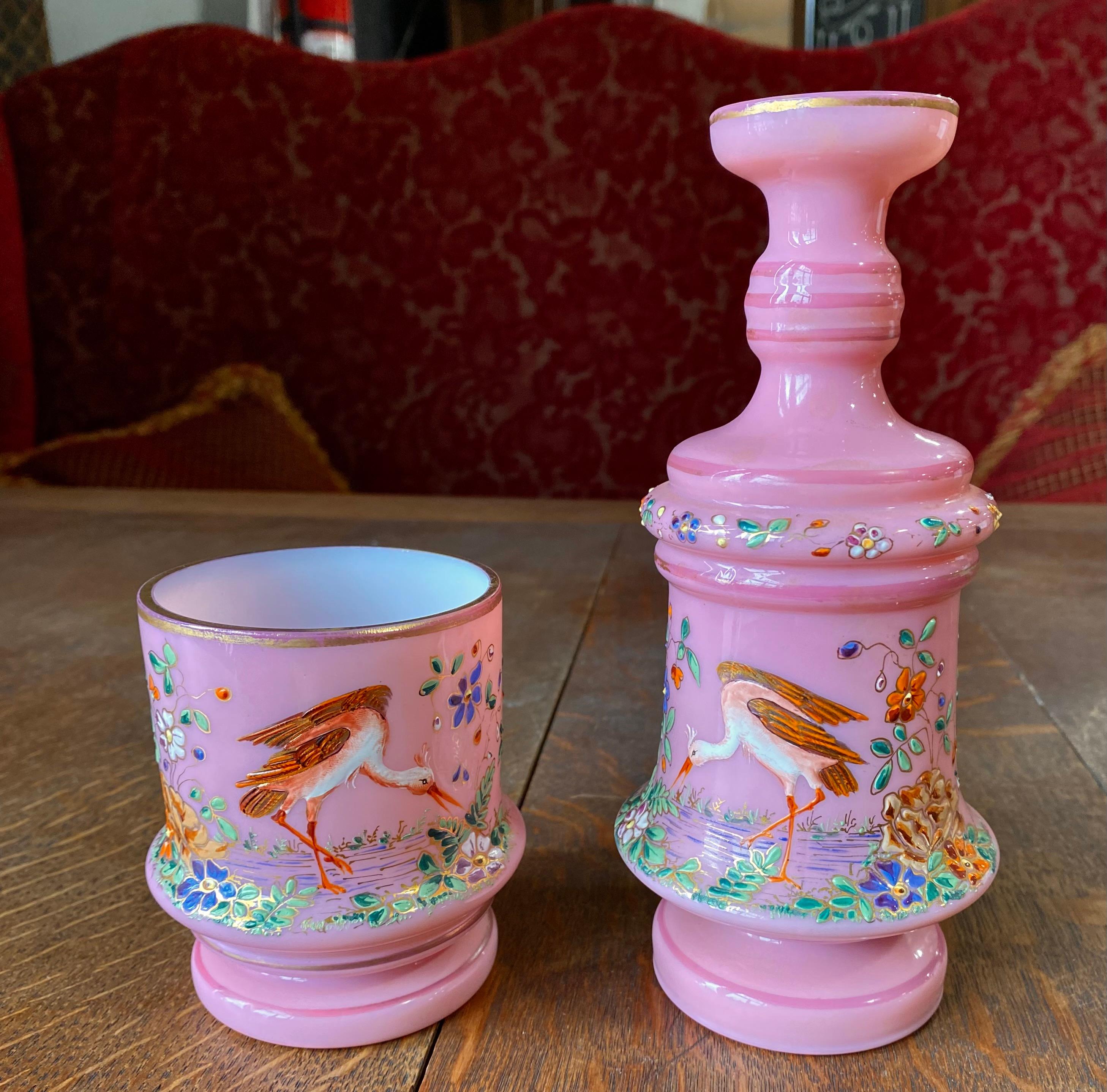 An exceptional and rare Moser Bohemia bedside carafe and associated drinking glass of enameled opaline glass in an exquisite pink color, the circular body beautifully hand painted all around the two pieces and with gold gilt.

Moser is a luxury