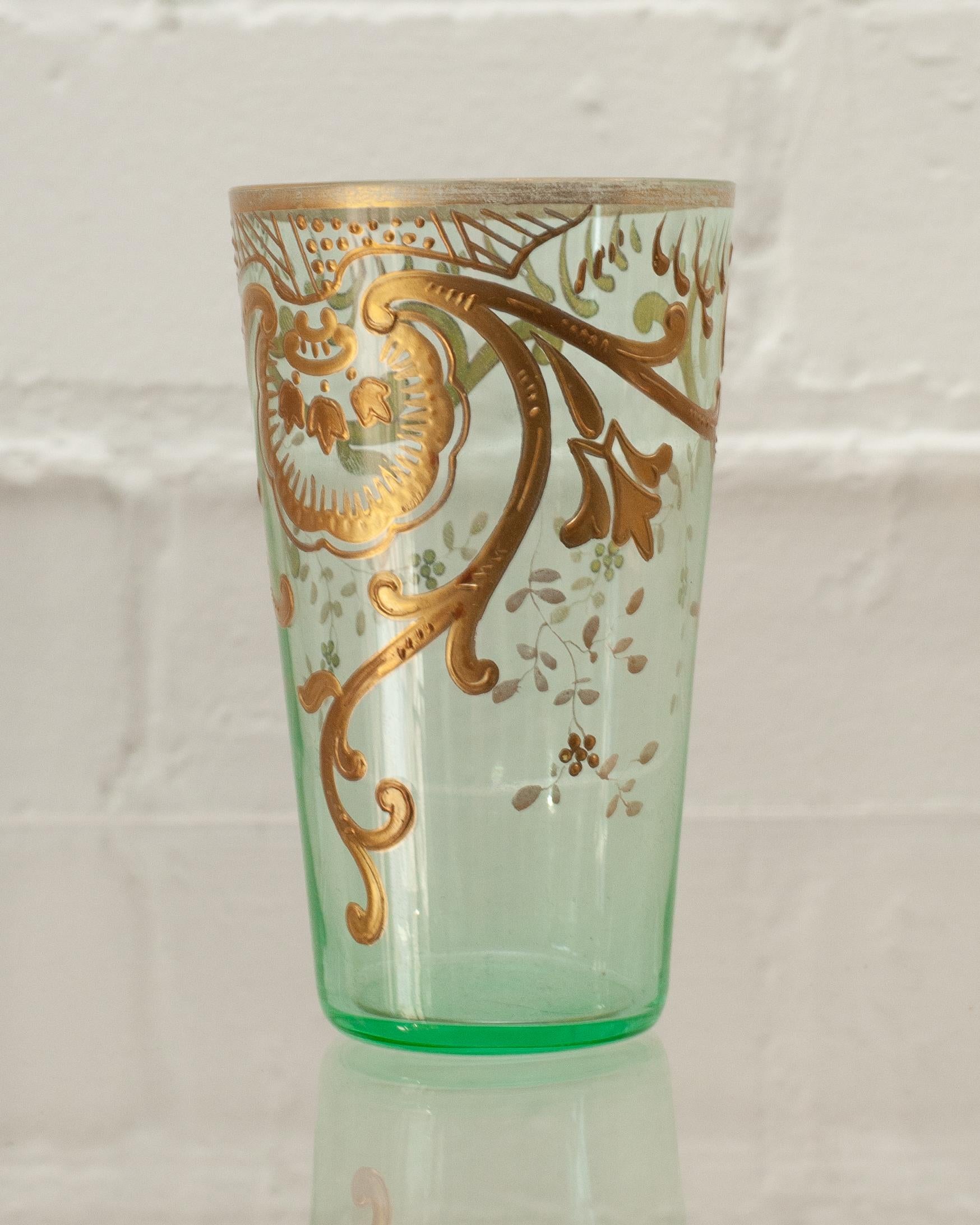 An usual and delicate set of 8 Antique Moser green & gold Moroccan style tea glasses. This thin sage green glass is gilded ornately in gold scroll motifs. Shown with Joy de Rohan Chabot Lily of the Valley Tray, sold separately.
     