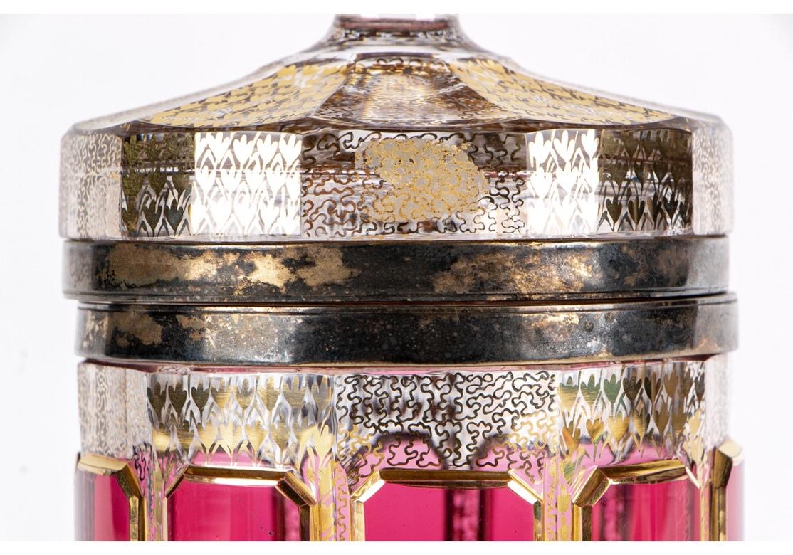 A circular faceted box with hinged lid, circa late 19th century. Overall gilt patterned decoration with raised ruby tone glass panels. The domed lid with faceted finial. Brass mounts.
Measure: Height 8