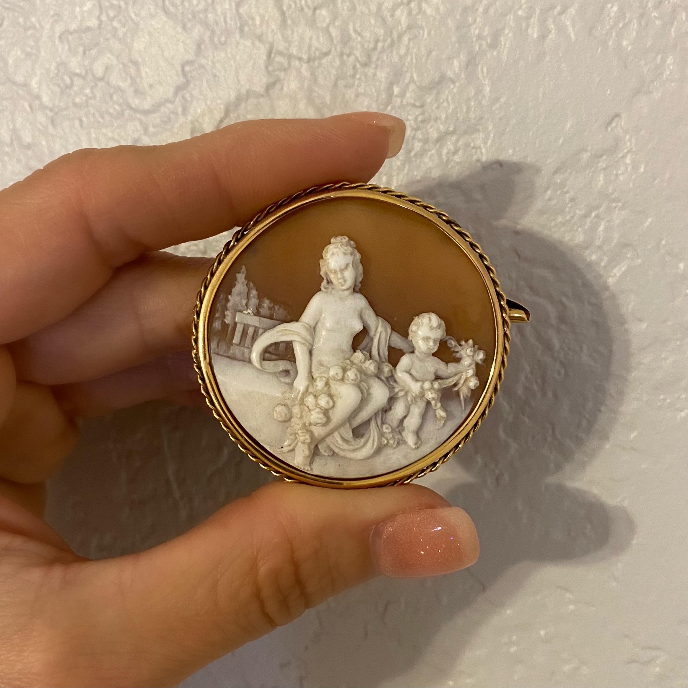 Simply Beautiful! Stylish Antique Hand carved Cameo Brooch depicting Mother and Child in Garden setting. Hand Carved in High Relief with exquisite detail. Set in a solid 18 Karat yellow Gold frame. An added cover over the end of the pin. Measuring