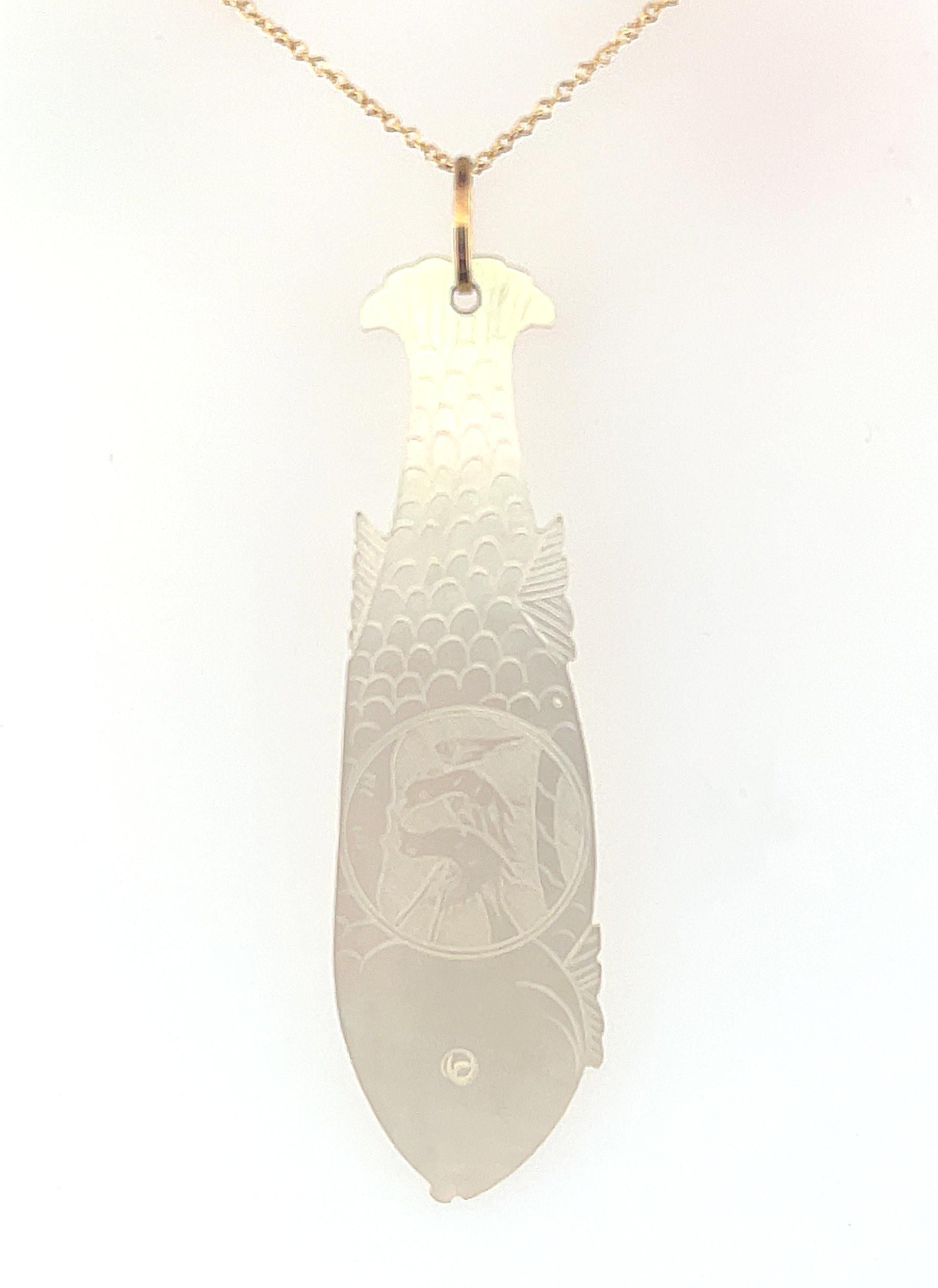 This unusual pendant features an antique, mother-of-pearl gambling counter in the shape of a fish. Originally carved in China for export to Britain, gaming counters or 