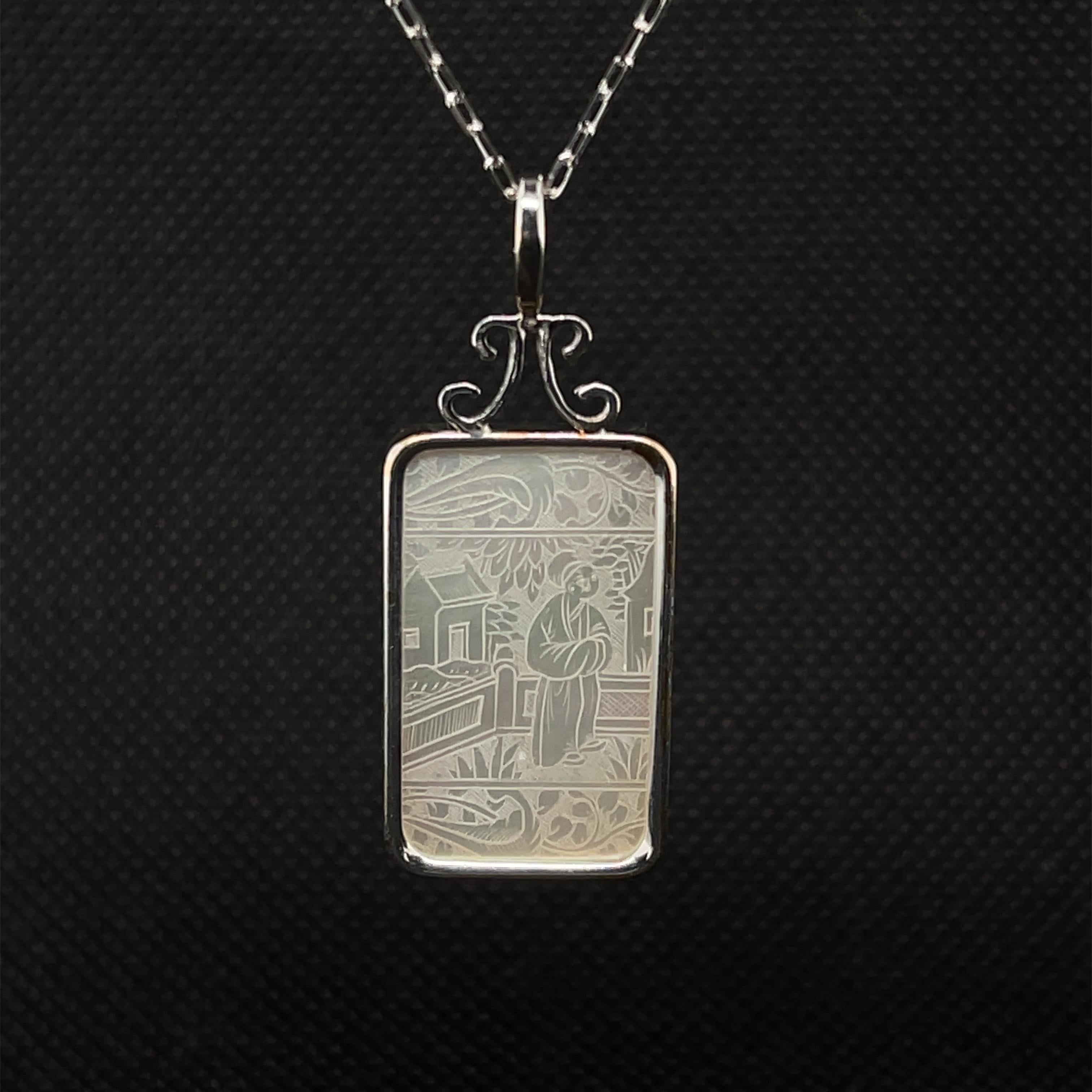 This pretty pendant / enhancer features an antique mother-of-pearl gaming counter that has been bezel set in 14k white gold. Gaming counters, or 