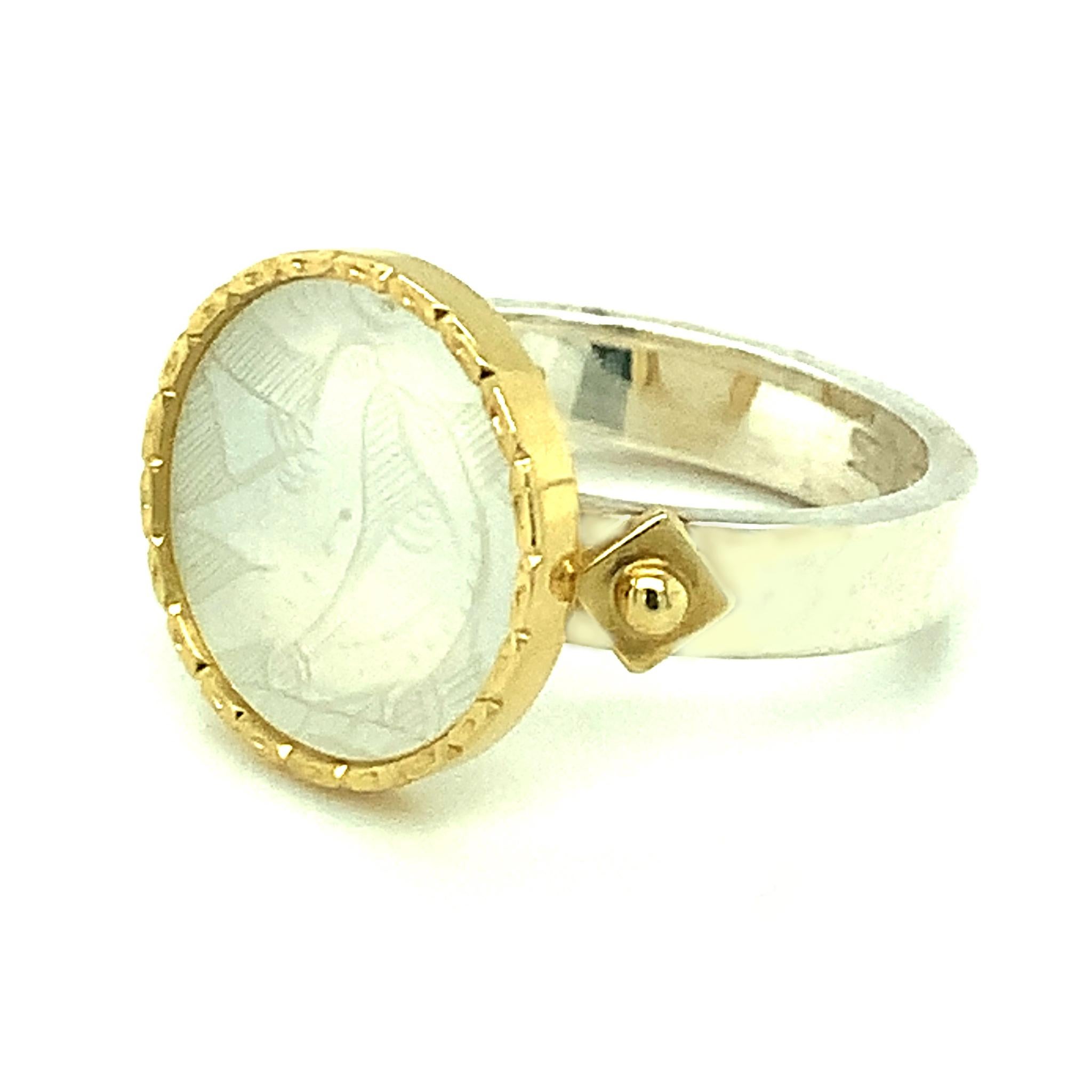 This ring features an antique, mother-of-pearl Chinese gambling counter with motifs dating back to the 18th century. The counter was originally carved in China for export to Britain. The British used these mother of pearl pieces much like we would