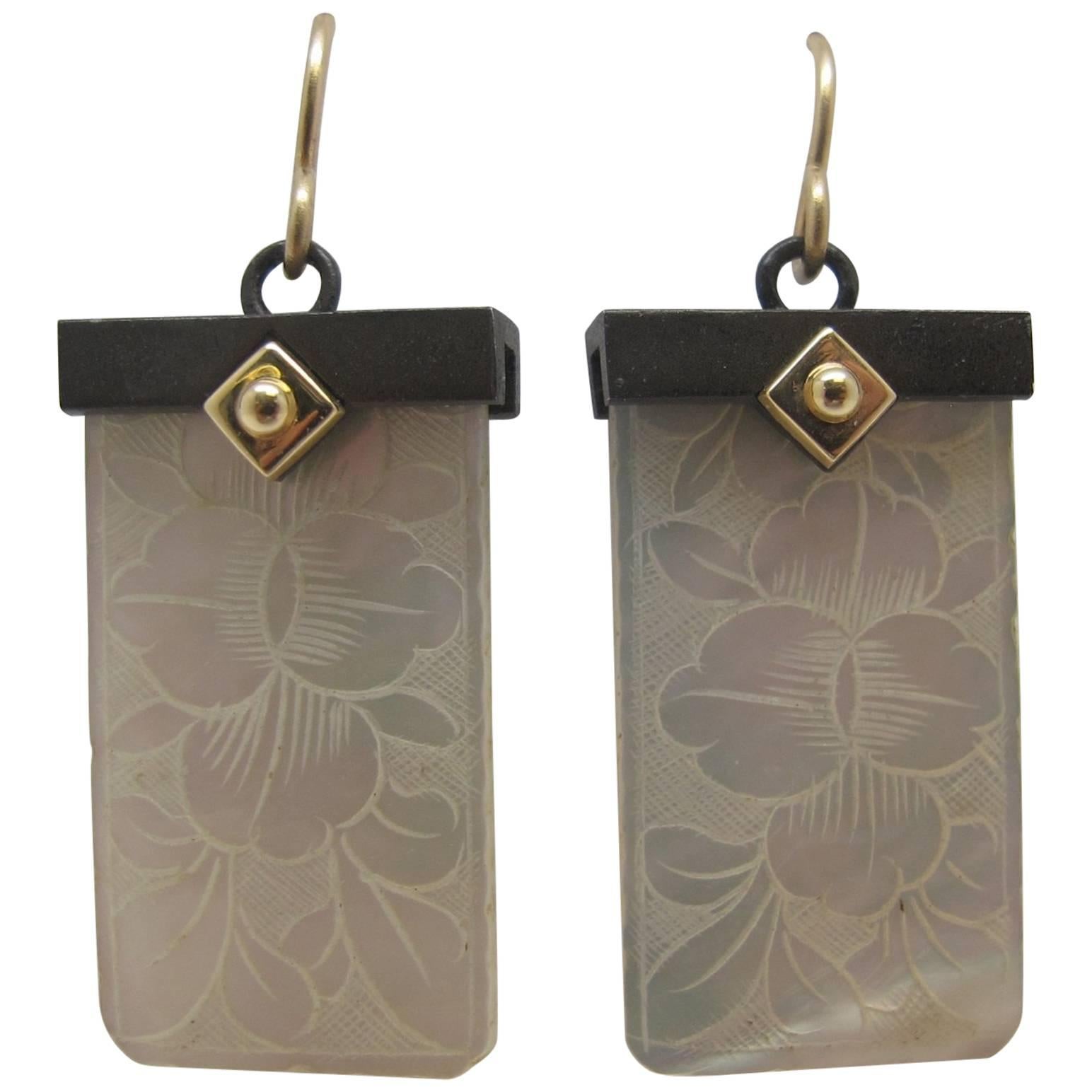 These earrings feature antique mother-of-pearl Chinese gambling counters with motifs dating back to the 18th Century. They were carved in China for export to Britain. The British used them like we would use a poker chip and played various games with