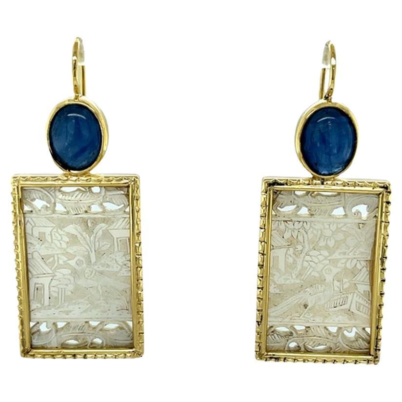 These gorgeous 18k yellow gold dangle earrings are set with hand-carved antique gaming counters that have been paired with royal blue kyanite cabochons for a look of cultured elegance and sophistication. Mother-of-pearl gaming counters were