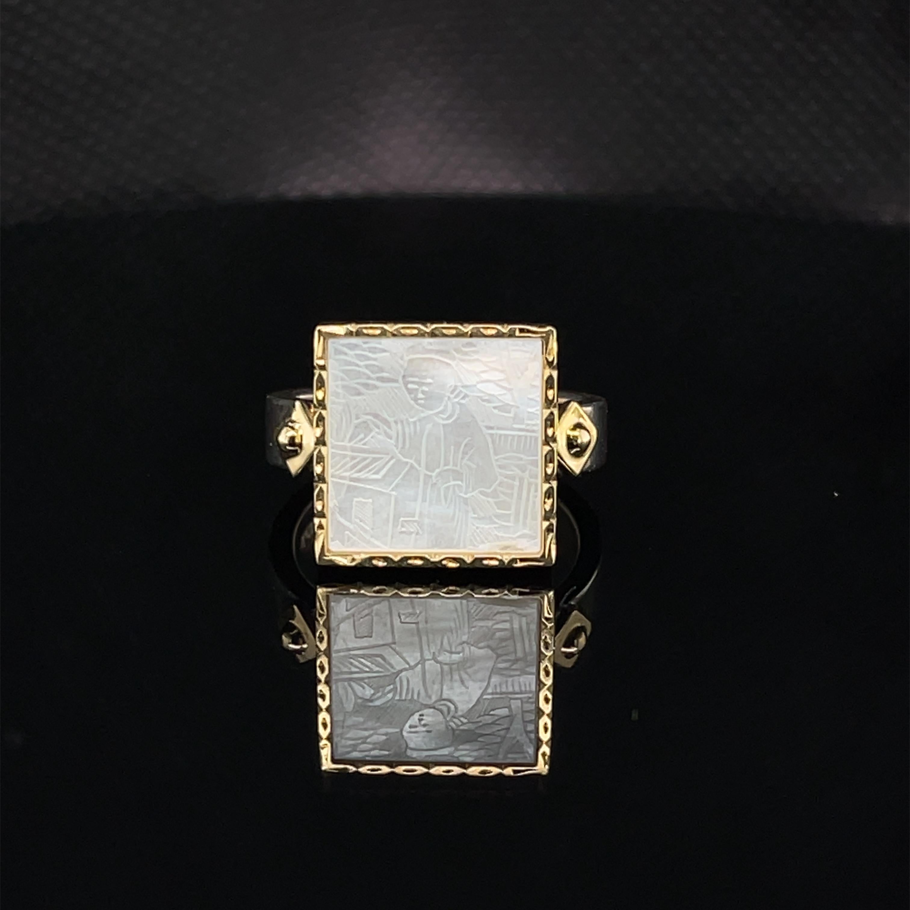 This elegant ring features an antique, mother-of-pearl Chinese gambling counter dating back to the 18th Century. The square gaming counter is set in a beautifully engraved 18k yellow gold frame. 18k yellow gold accents adorn the sterling silver band
