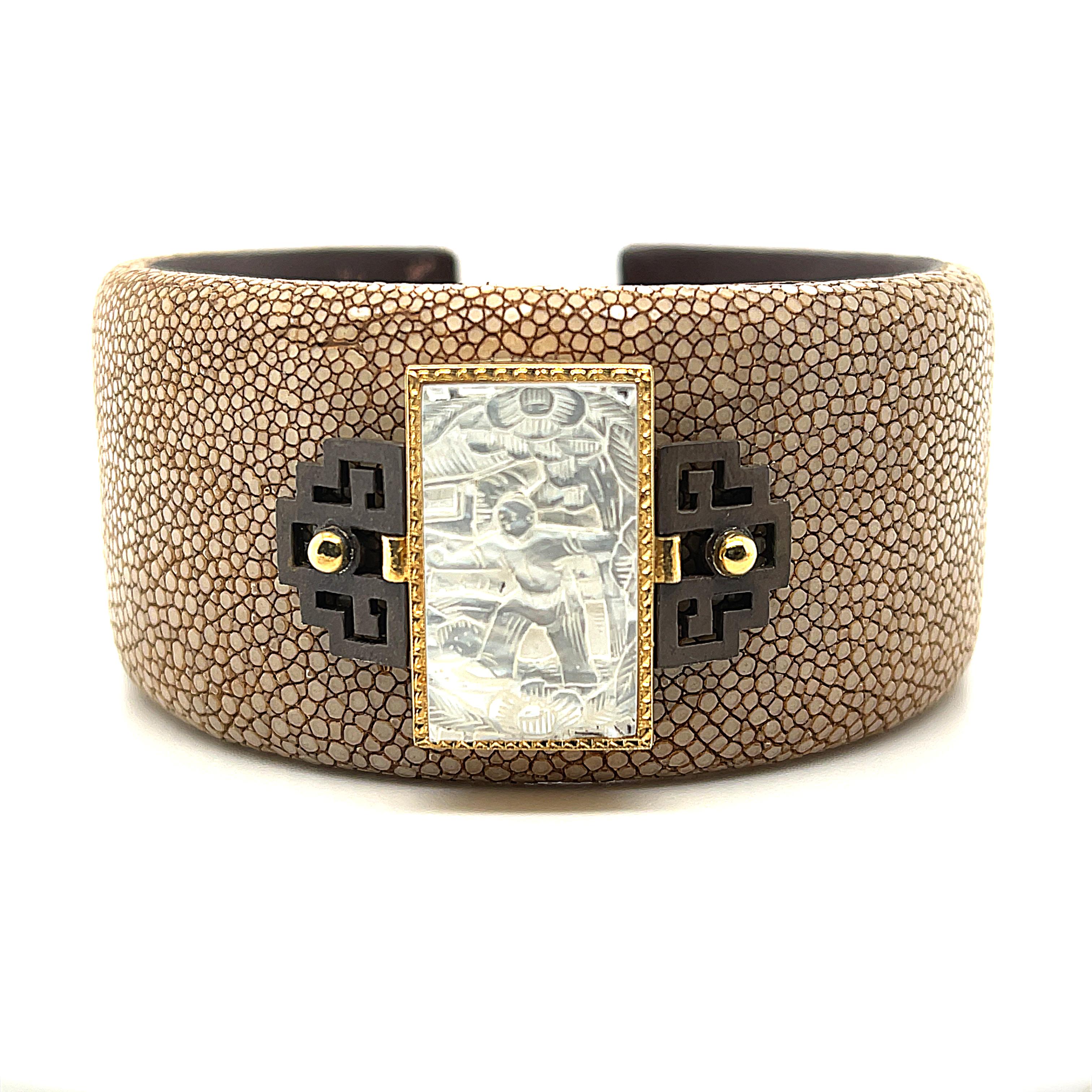 This 18k yellow gold shagreen cuff bracelet in taupe features an antique mother-of-pearl Chinese gambling counter with motifs dating back to the 18th Century. Originally carved in China for export to Britain, these counters were used much like we