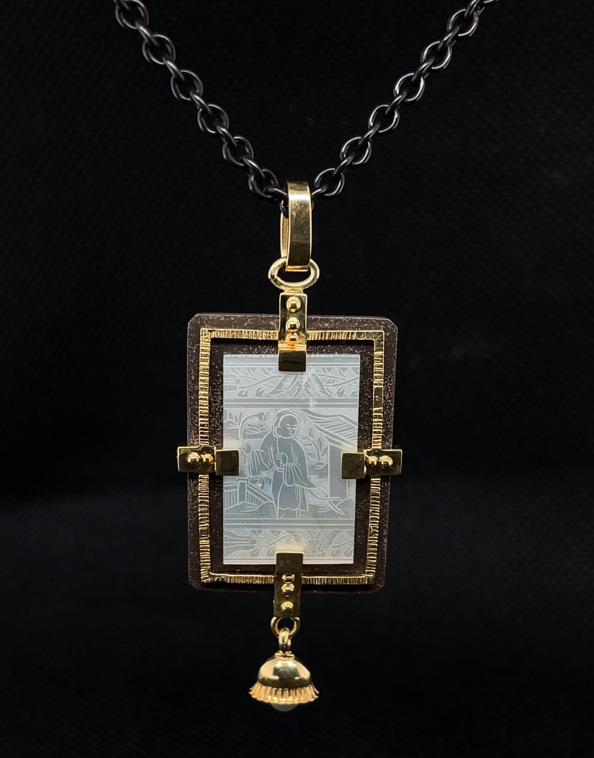 This striking necklace features an antique, mother-of-pearl Chinese gambling counter dating back to the 18th Century. The rectangular gaming counter is framed in rich 18k yellow gold and blackened silver, in an eye-catching design that looks