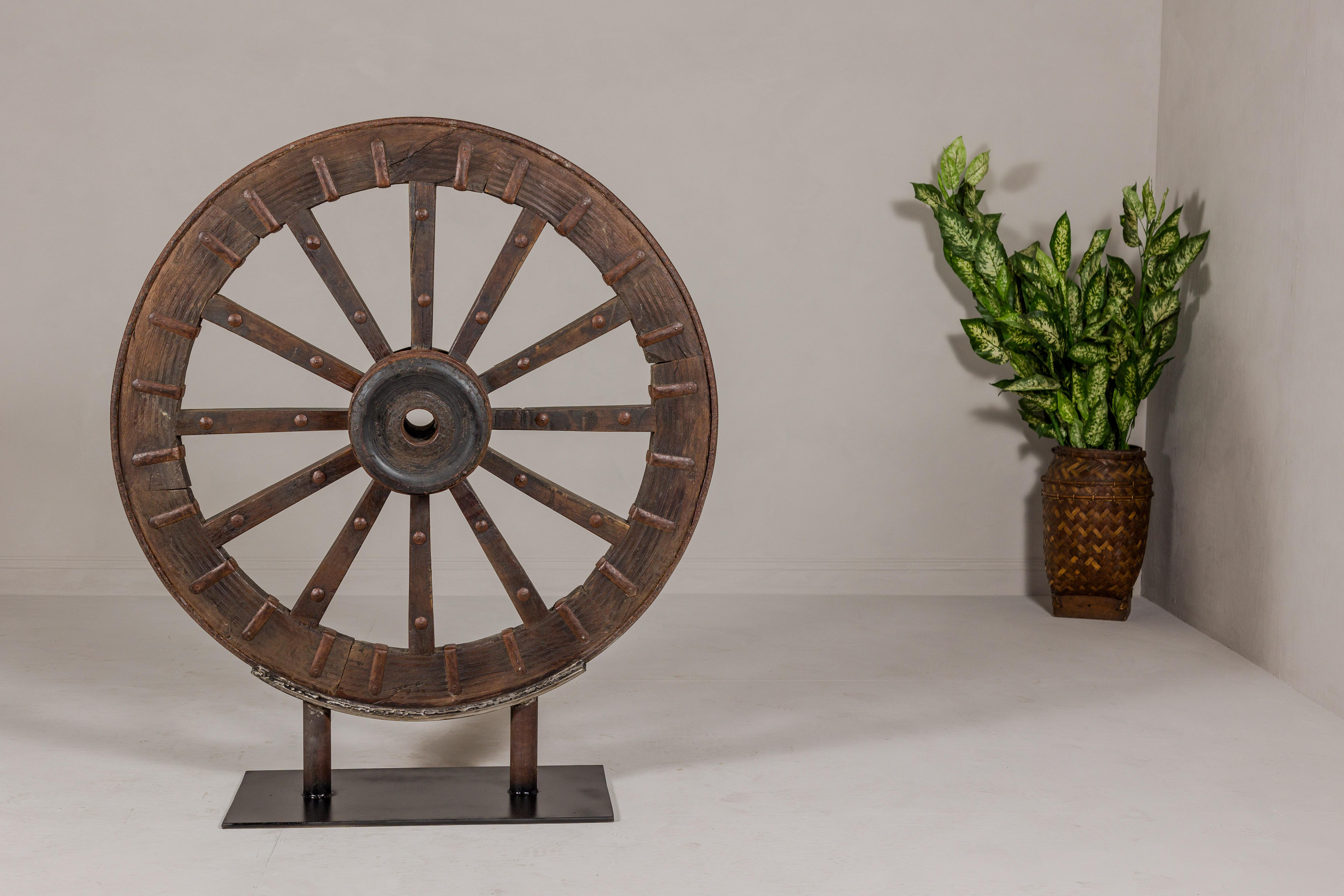Rustic Antique Mounted Wood and Metal Wheel Welded to a Custom Metal Base For Sale