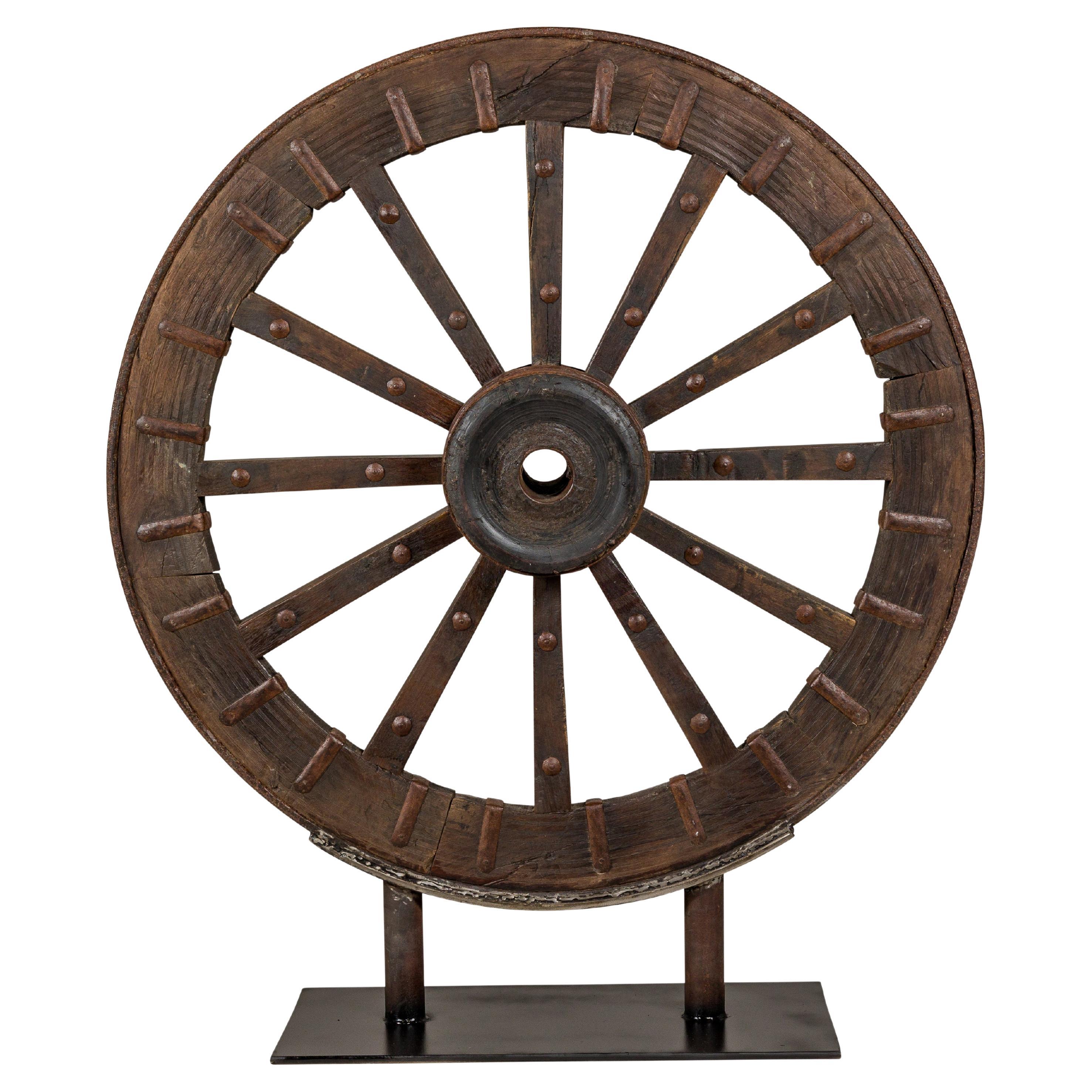Antique Mounted Wood and Metal Wheel Welded to a Custom Metal Base For Sale