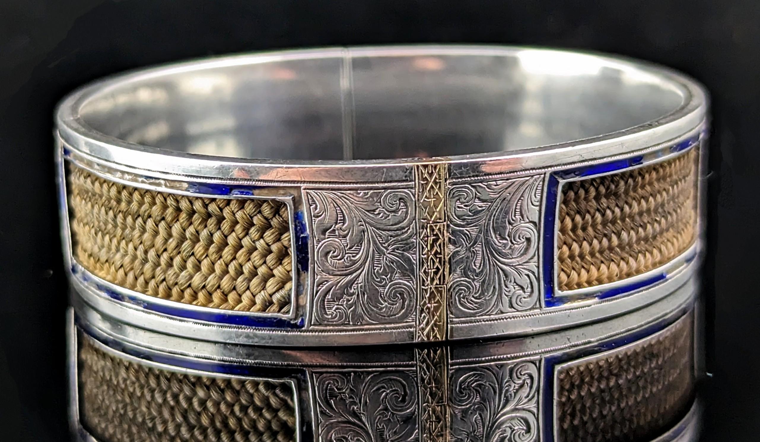 This unusual antique mourning bangle is so sweet and sentimental.

It is an interesting and unusual design, the bangle designed in a typical aesthetic era manner in engraved sterling silver.

It has inlaid 9ct gold sections and finely plaited light
