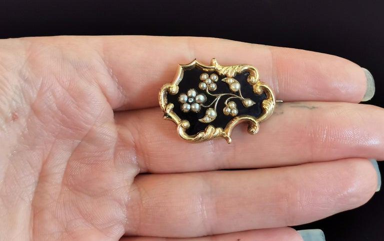 A beautiful, fine antique Victorian mourning brooch.

Crafted in 9ct gold with a rich aged patina, the brooch has a naturalistic scrolling shape and design with lightly textured areas of gold.

The brooch has been finished in inky black enamel, the