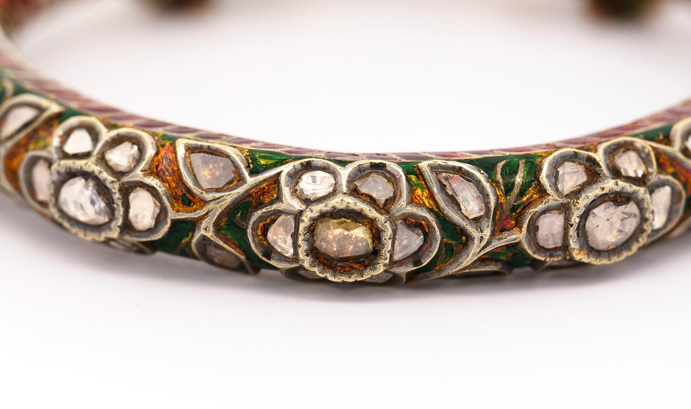 Dieses exquisite antike Armreifset aus der Mitte des späten 19. Jahrhunderts zeigt die komplizierte Handwerkskunst der Mogulzeit. Die aus 22-karätigem Gelbgold gefertigten Armreifen bestechen durch ihre rote, blaue und grüne Emaille und die